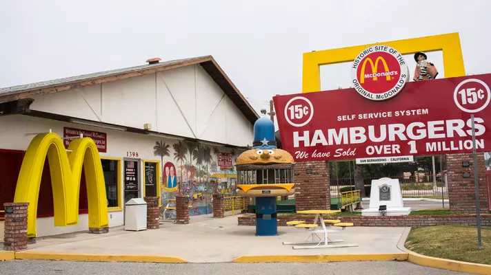 A giant McDonald’s sign and other memorabilia is displayed next to a building.