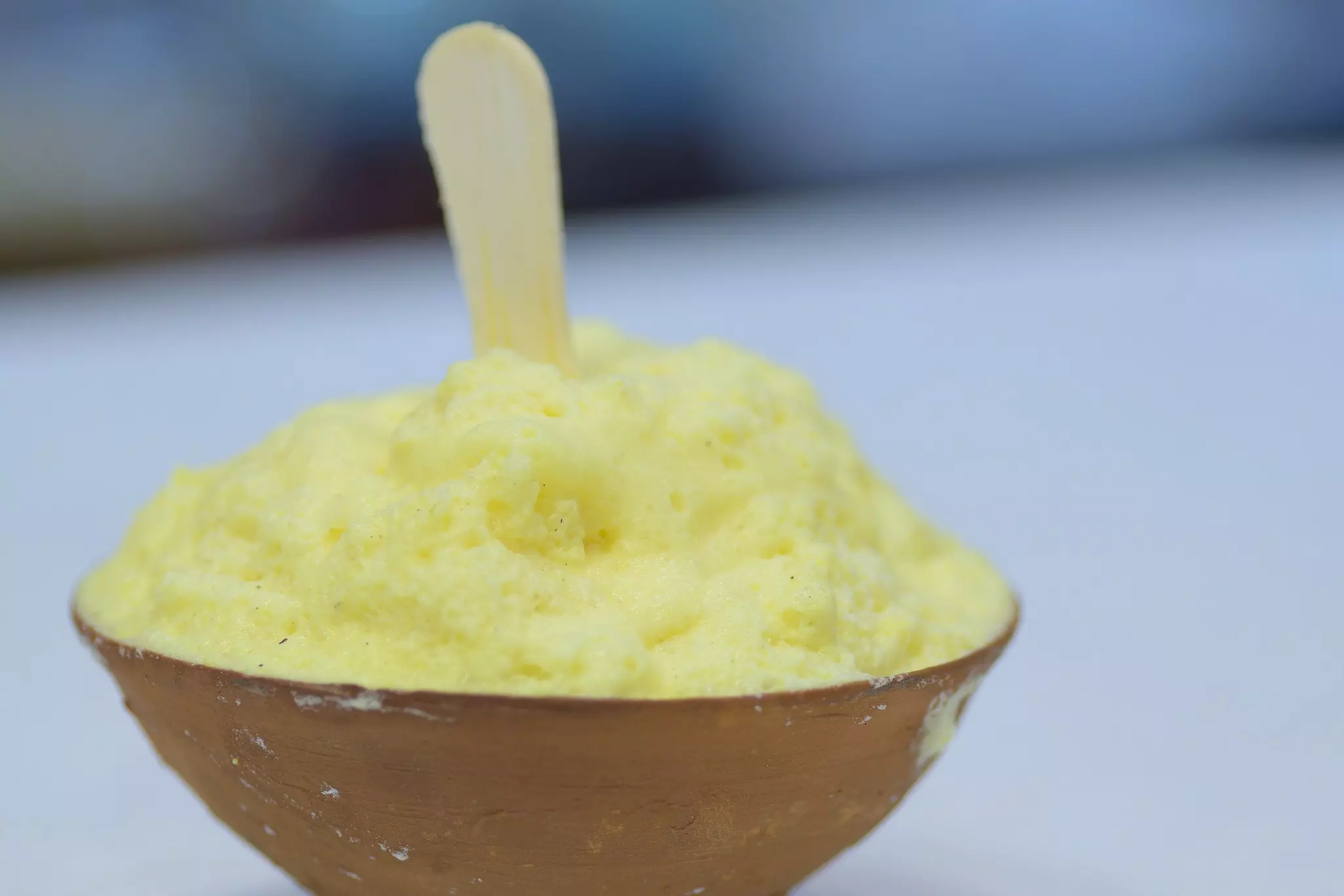 A close-up view of a fluffy, milky dessert in a clay pot.