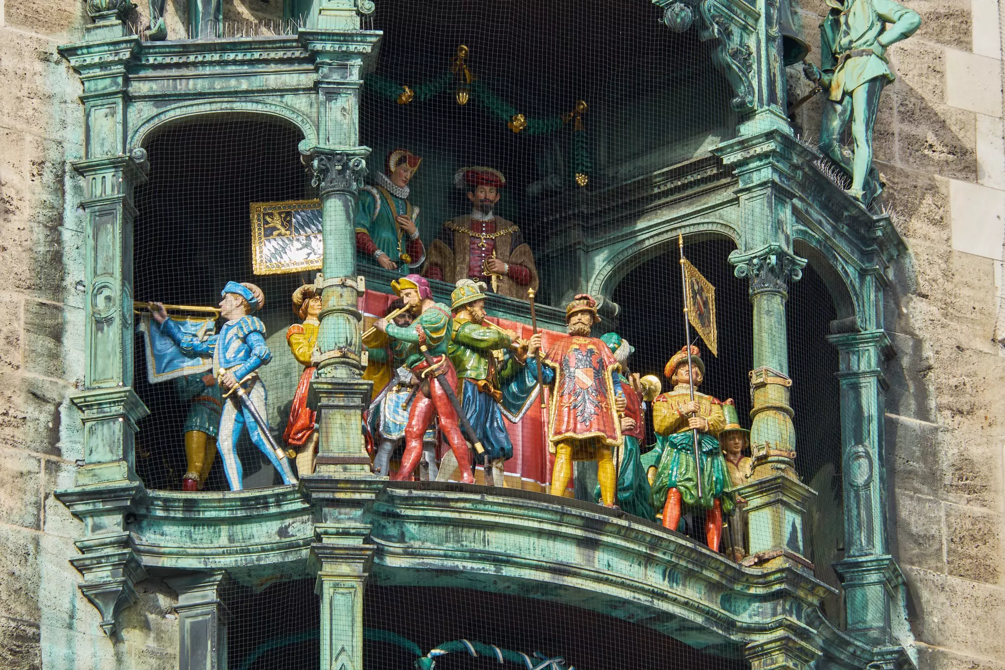 Colorful mechanical figurines move on an elaborate clock mechanism, part of a historic building.