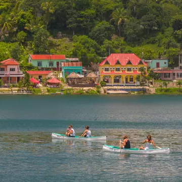 Tourists paddle canoes on Peten Itza lake in Guatemala