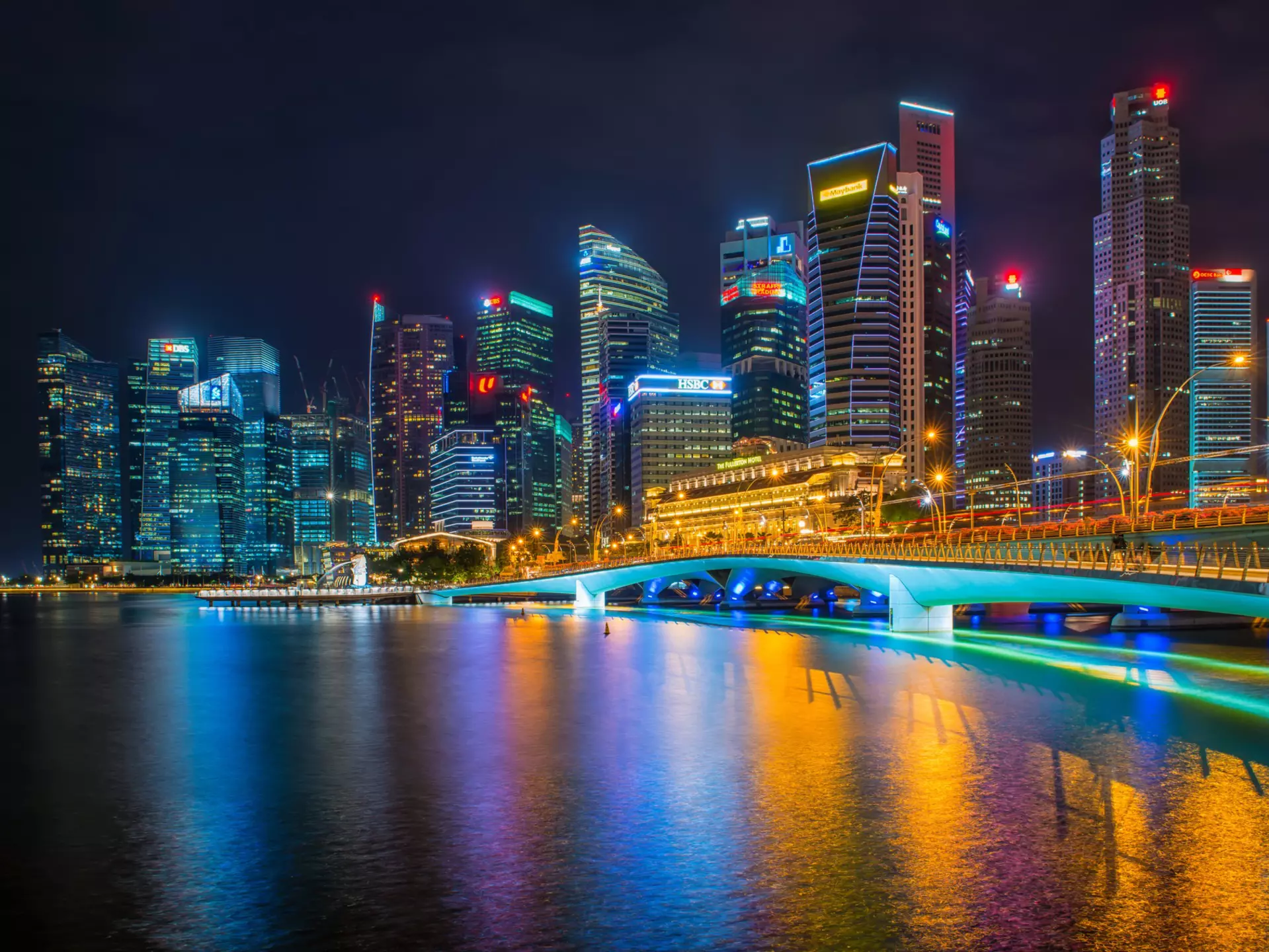 Commercial skyscrapers in Marina Bay and Merlion Park at night time of Singapore.