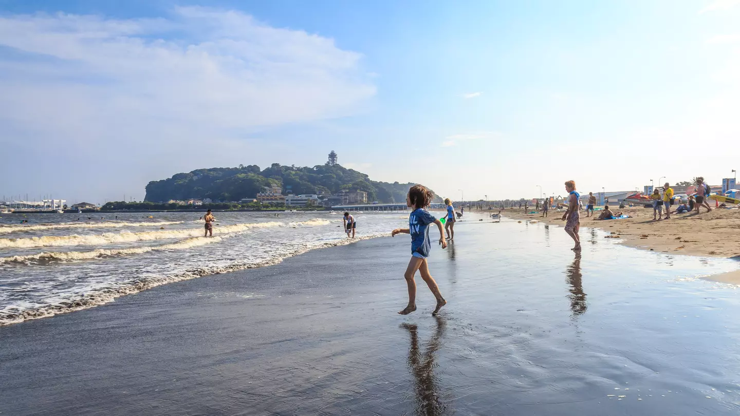A boy is going to the Katase Higashihama beach against sky, Fujisawa-kanagawa, Japan