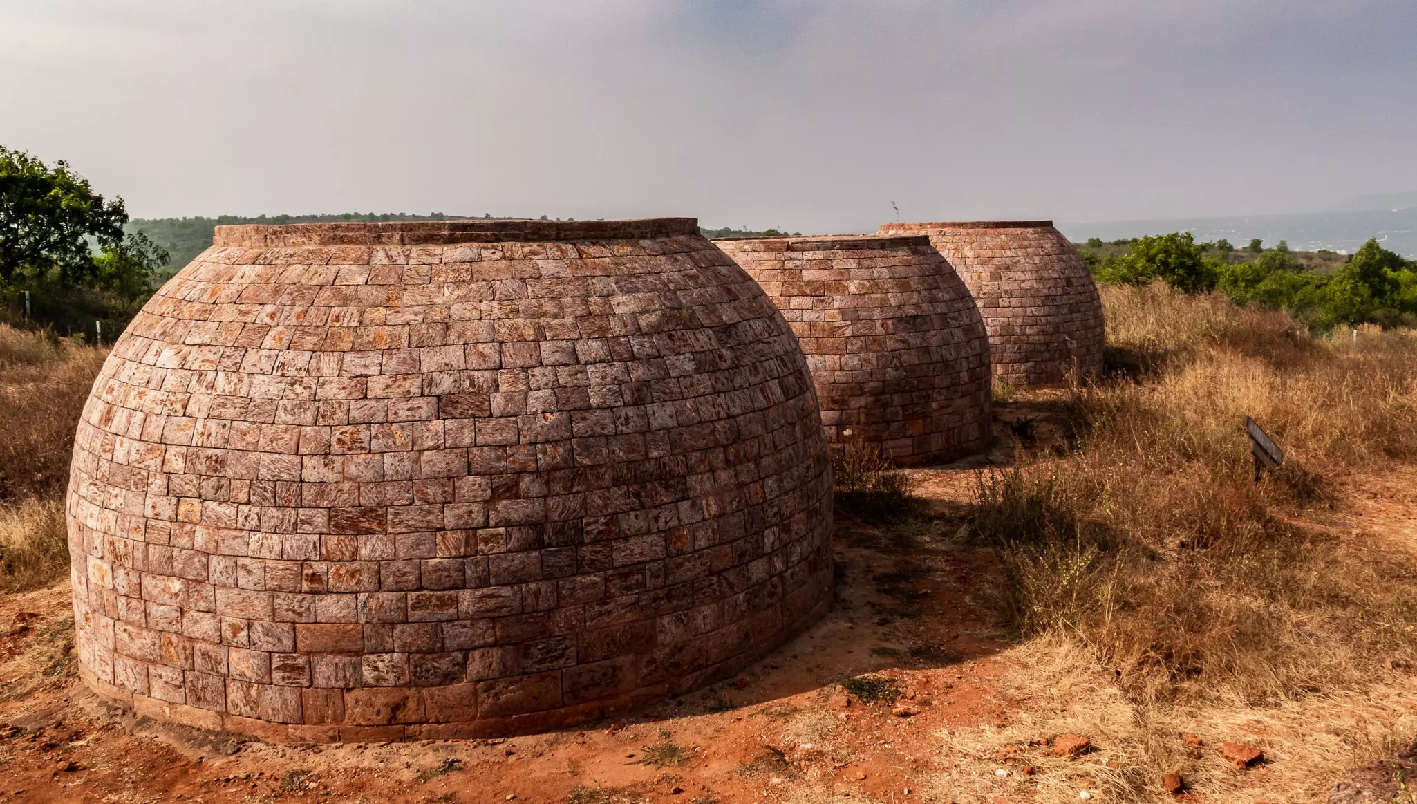 Three large brick wells on a hilltop