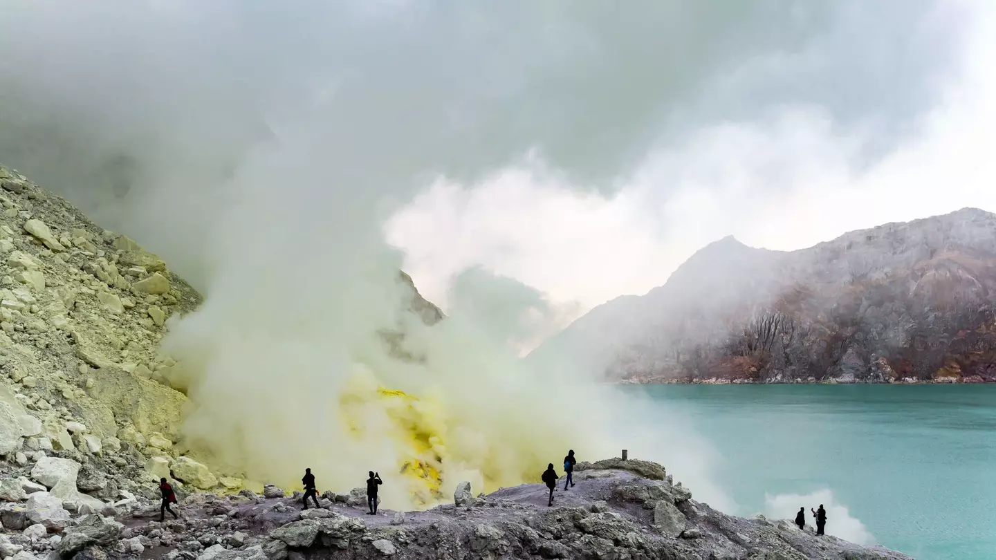 Tourists walking to see the sulfur mines and blue green lakes in Ijen crater, Indonesia