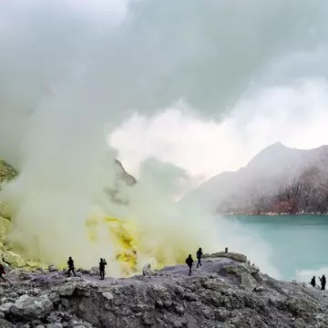 Tourists walking to see the sulfur mines and blue green lakes in Ijen crater, Indonesia