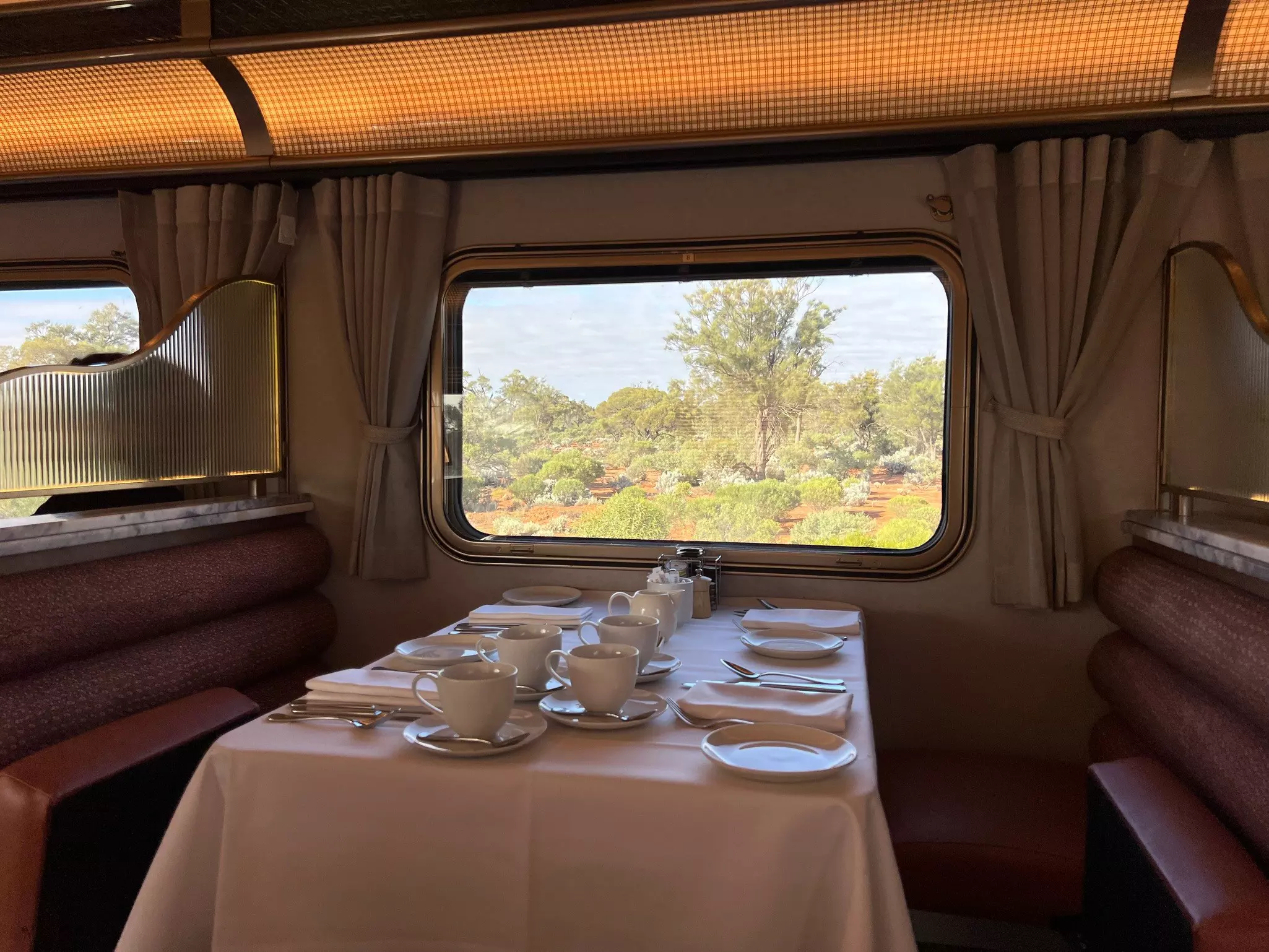 View of dining table laid out for a meal with window beyond on the Indian Pacific train in Australia