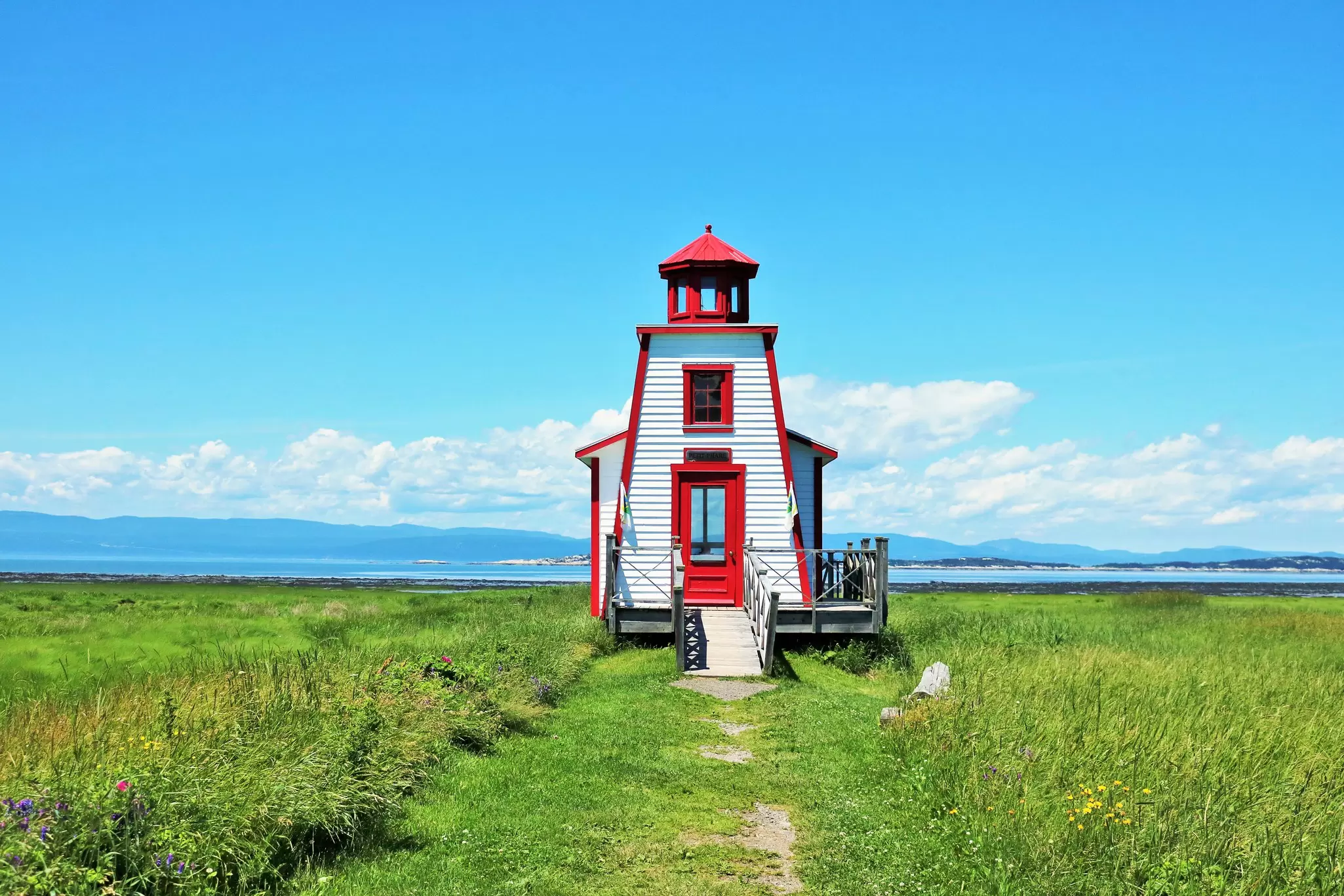 White and red lighthouse in a field 