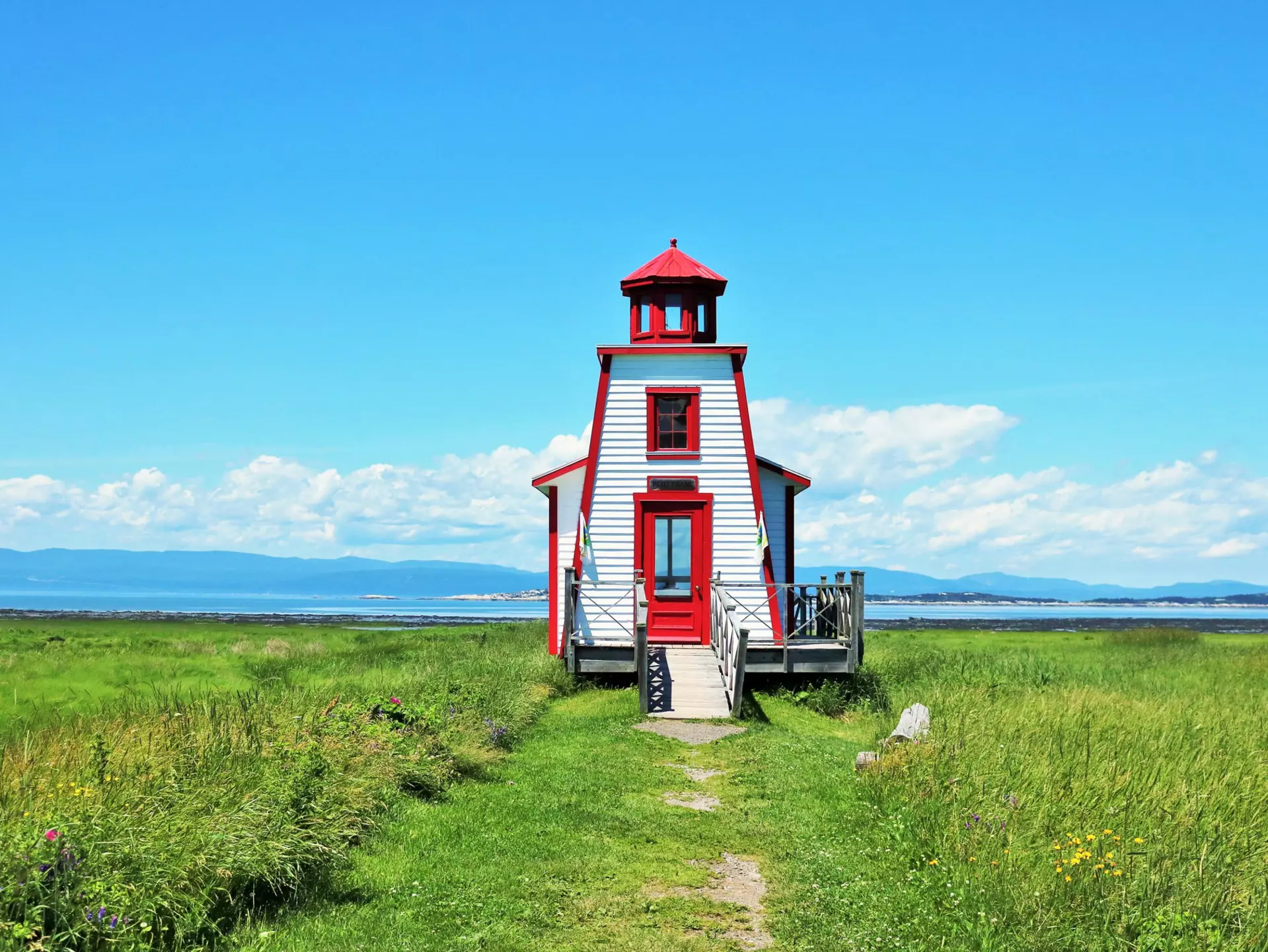 White and red lighthouse in a field 
