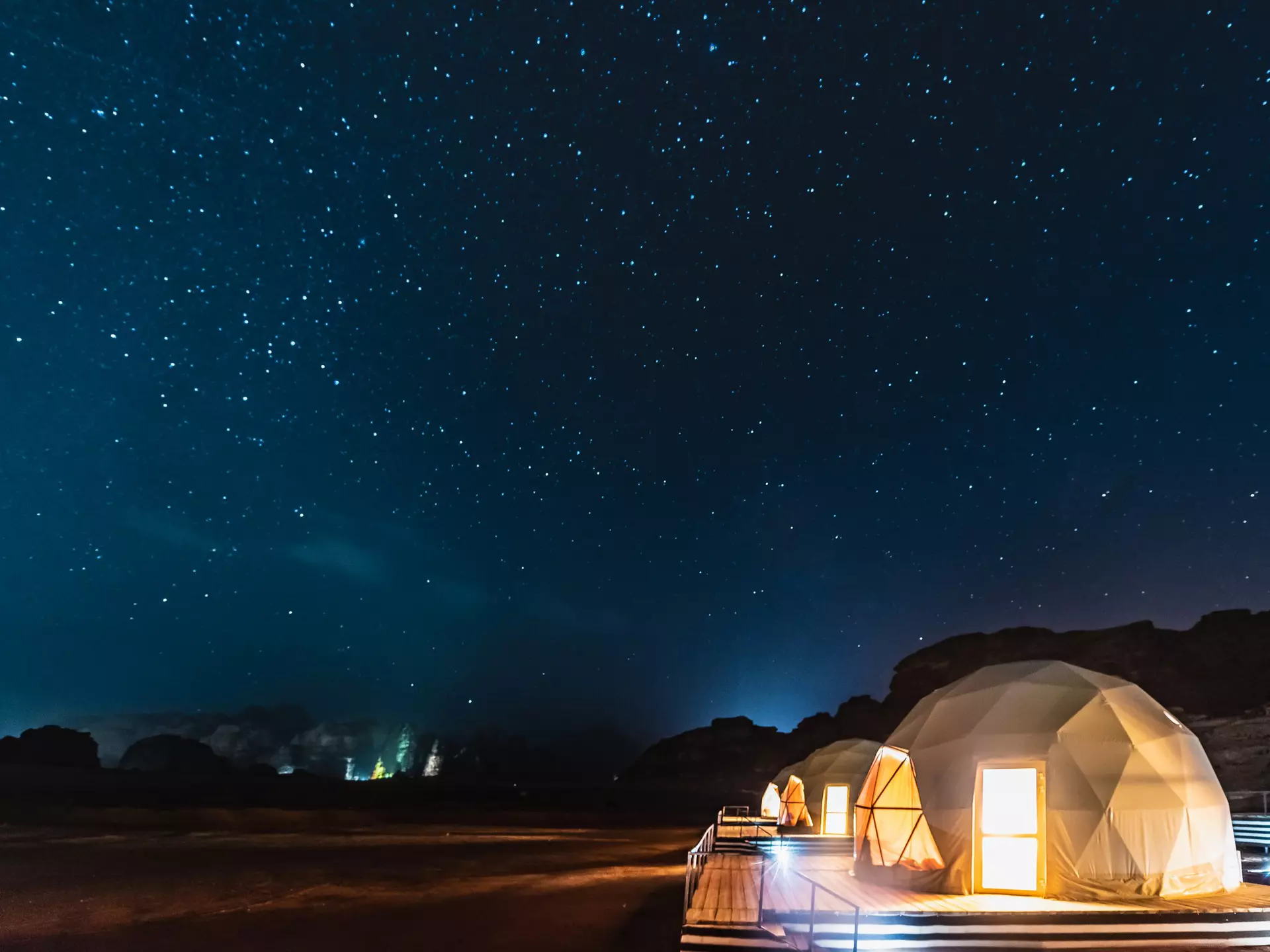 Stars above domed tents in a desert area