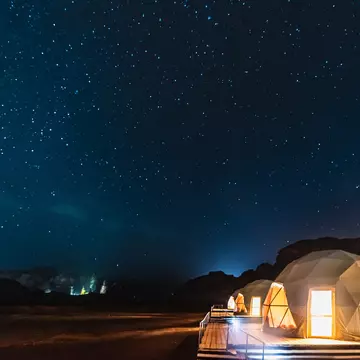 Stars above domed tents in a desert area