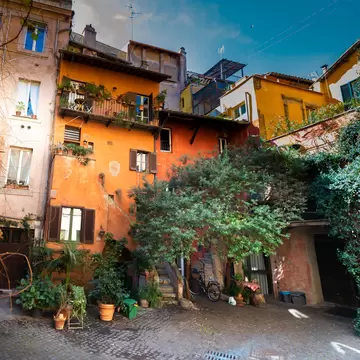 Small courtyard in Rome , with rustic ocher houses and vine trees.