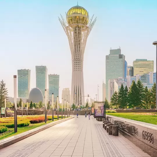 Astana, Kazakhstan – July 17, 2025: The iconic Bayterek Tower stands tall amidst the modern skyline and lush green park of Astana, Kazakhstan. A sunny day view of the city's urban landscape.