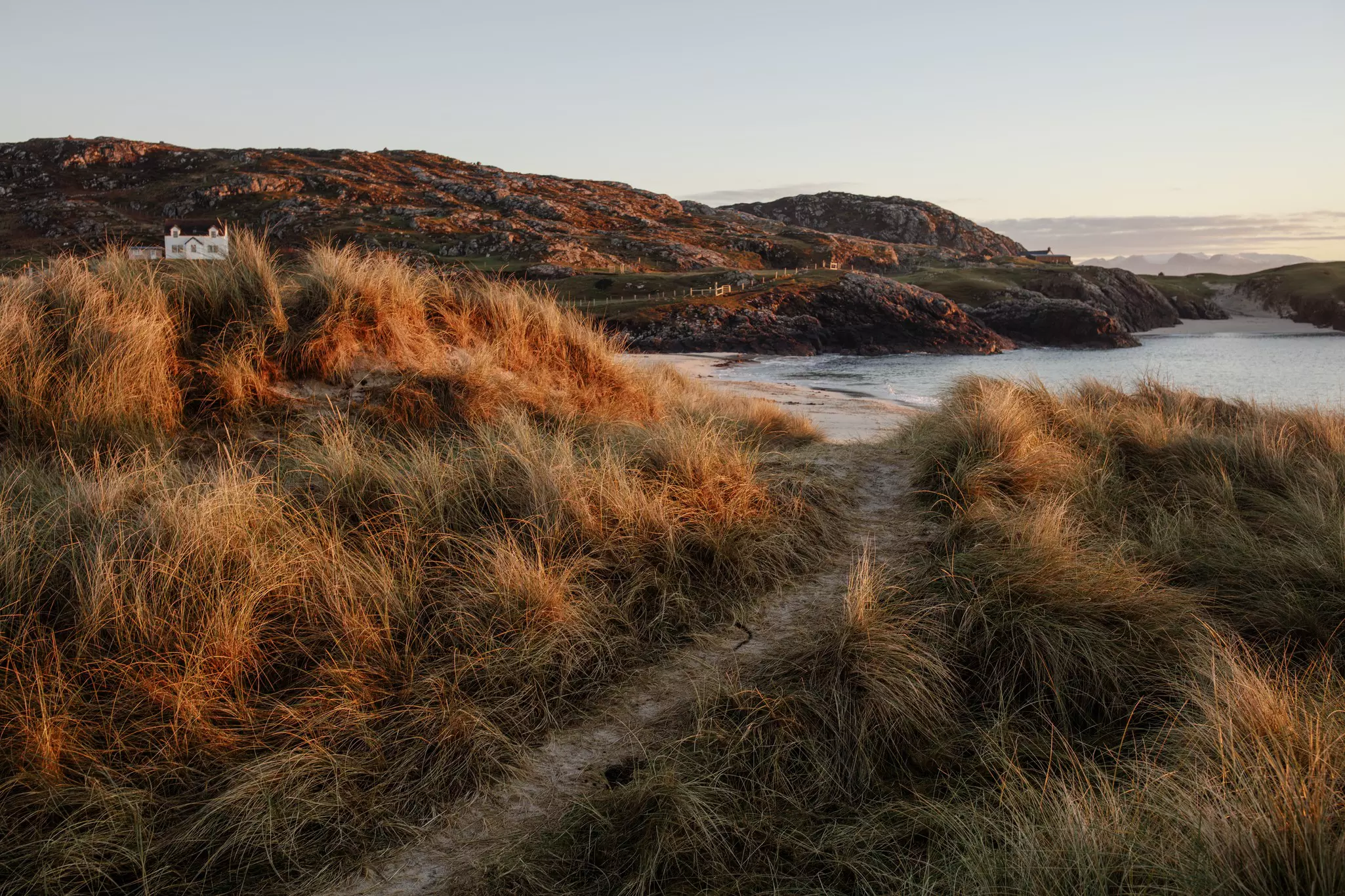Grassy dunes at Clachtoll Beach at sunset on the NC500 driving route in Scotland.