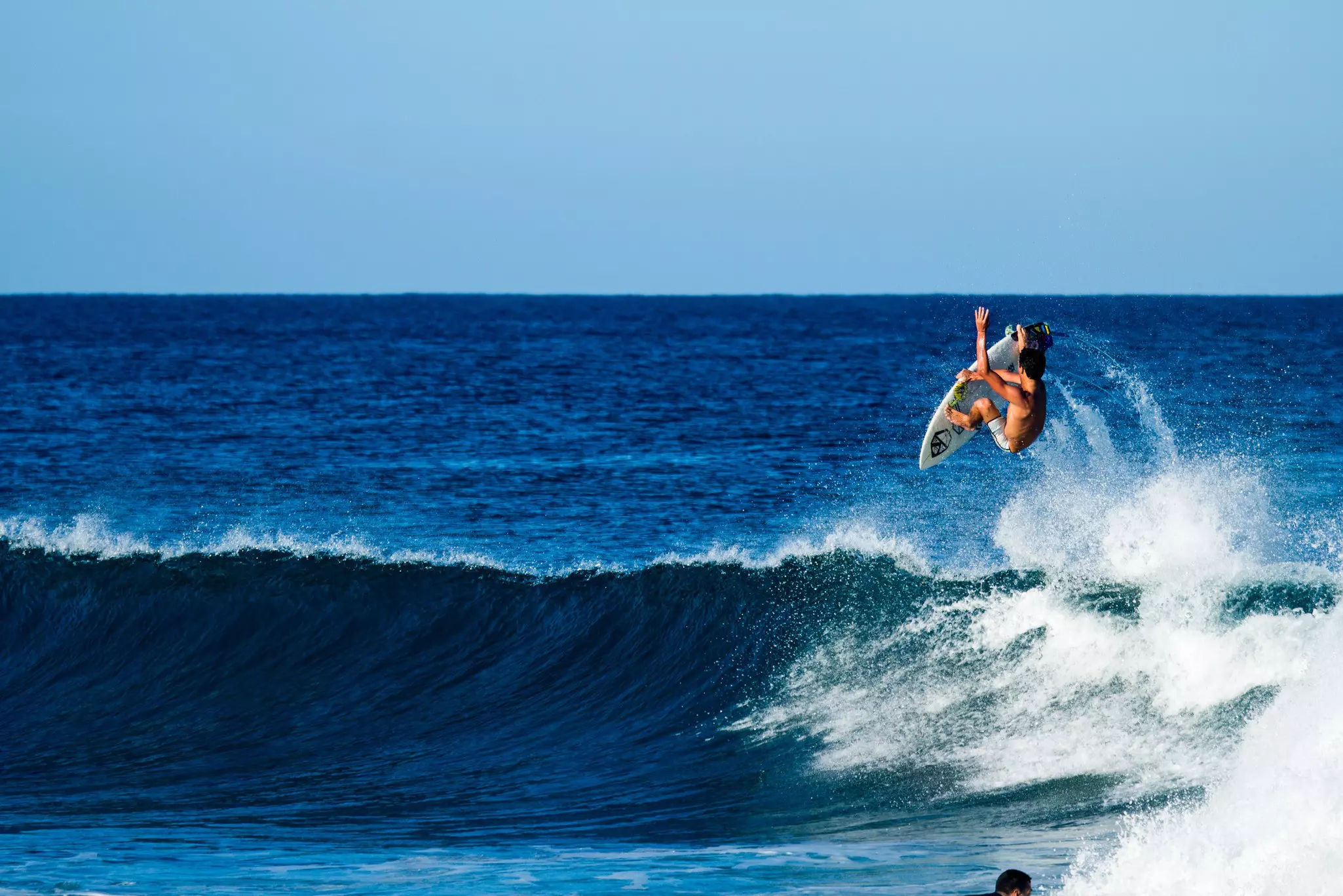 A surfer up in the air after riding a wave in Rincón