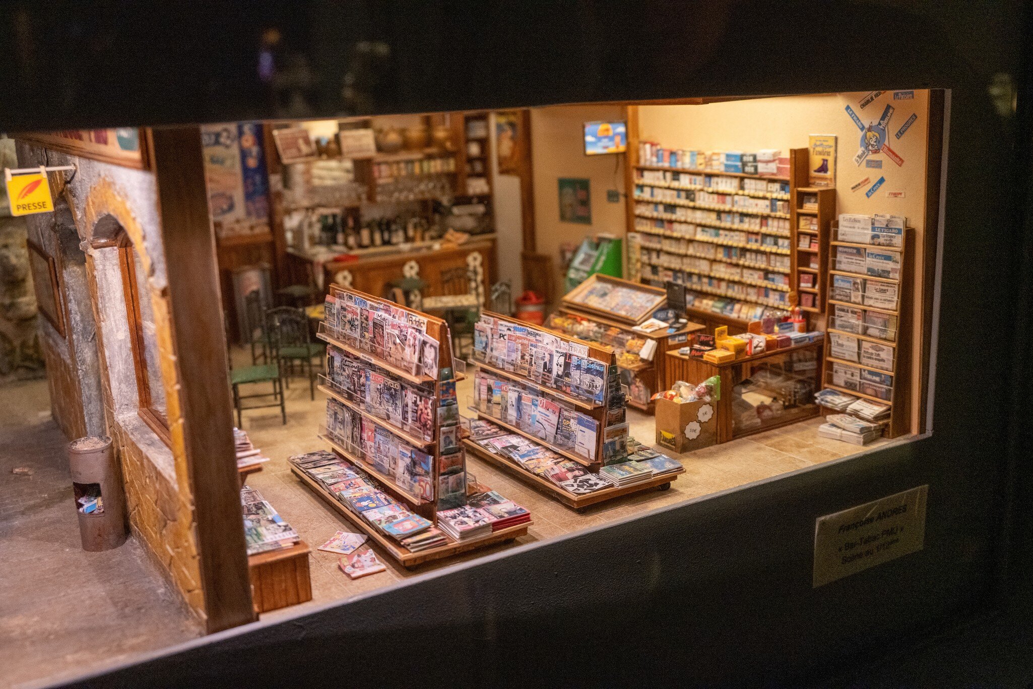 Highly detailed miniature newsstand and shop interior displayed as a film set model at the Musee Cinema et Miniature in Lyon, France.