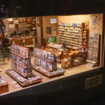 Highly detailed miniature newsstand and shop interior displayed as a film set model at the Musee Cinema et Miniature in Lyon, France.