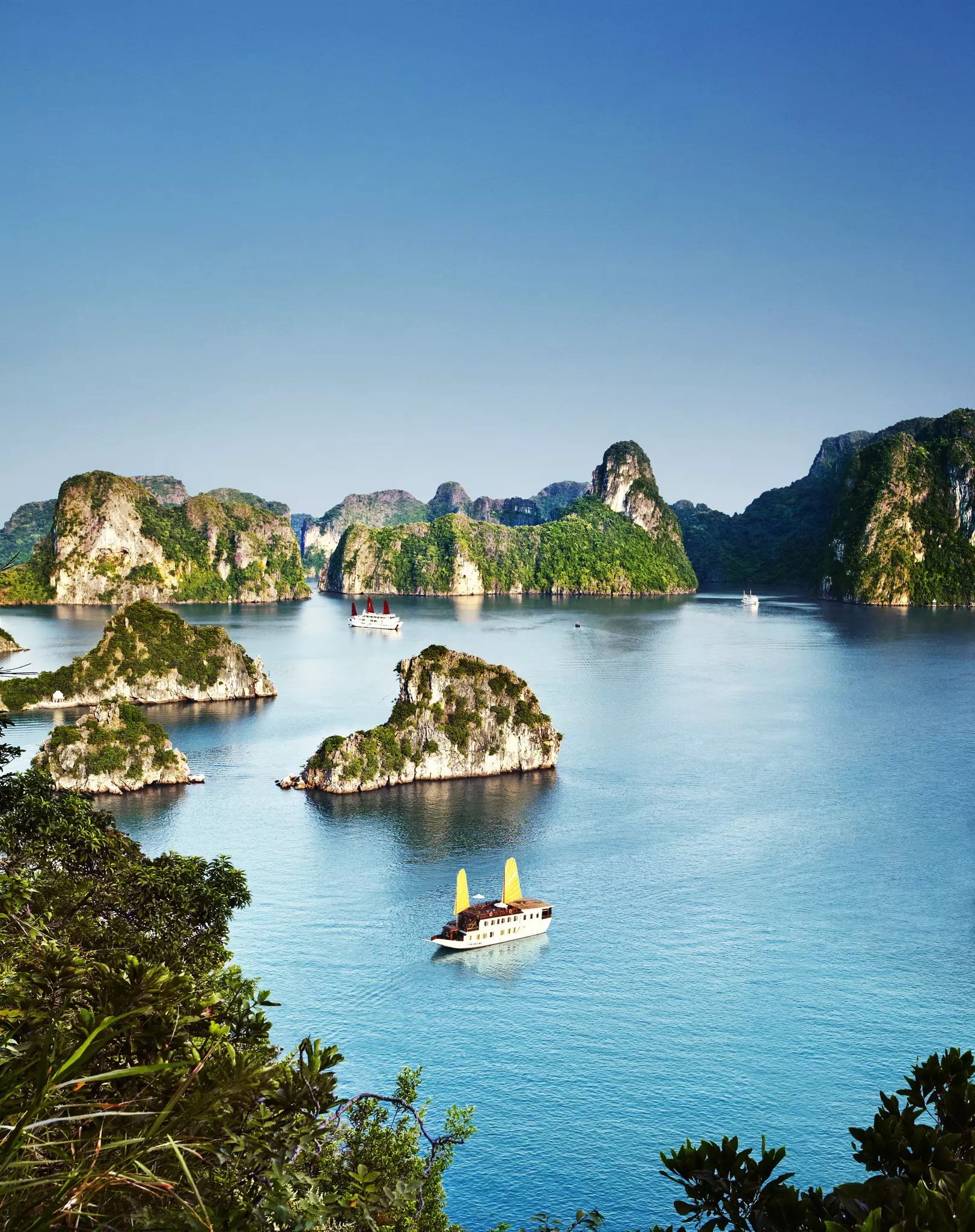 Chinese junks cruise by limestone islands in Halong Bay