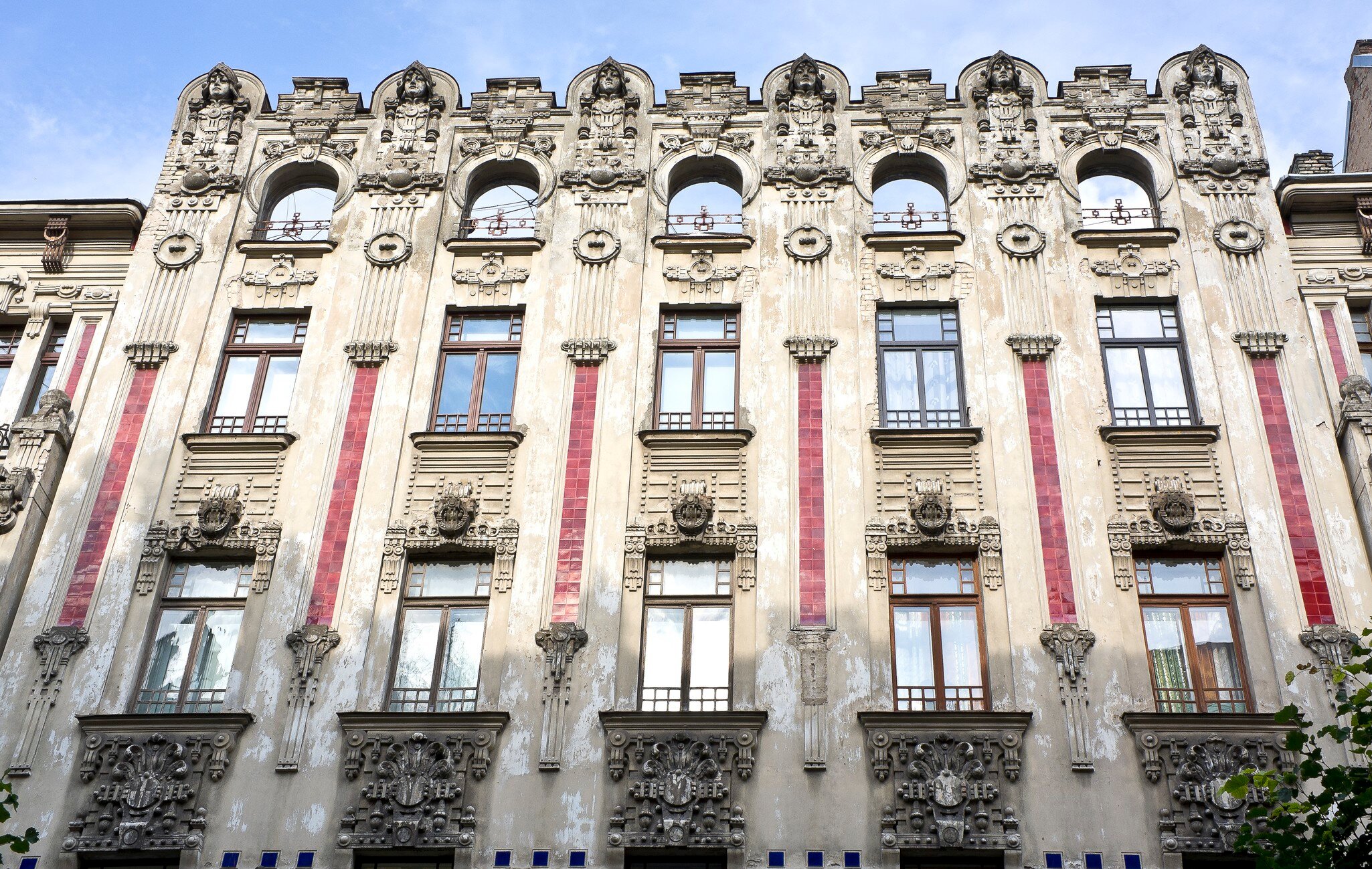 An Art Noveau–style building with stone and tile exterior.