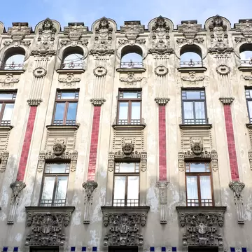 An Art Noveau–style building with stone and tile exterior.