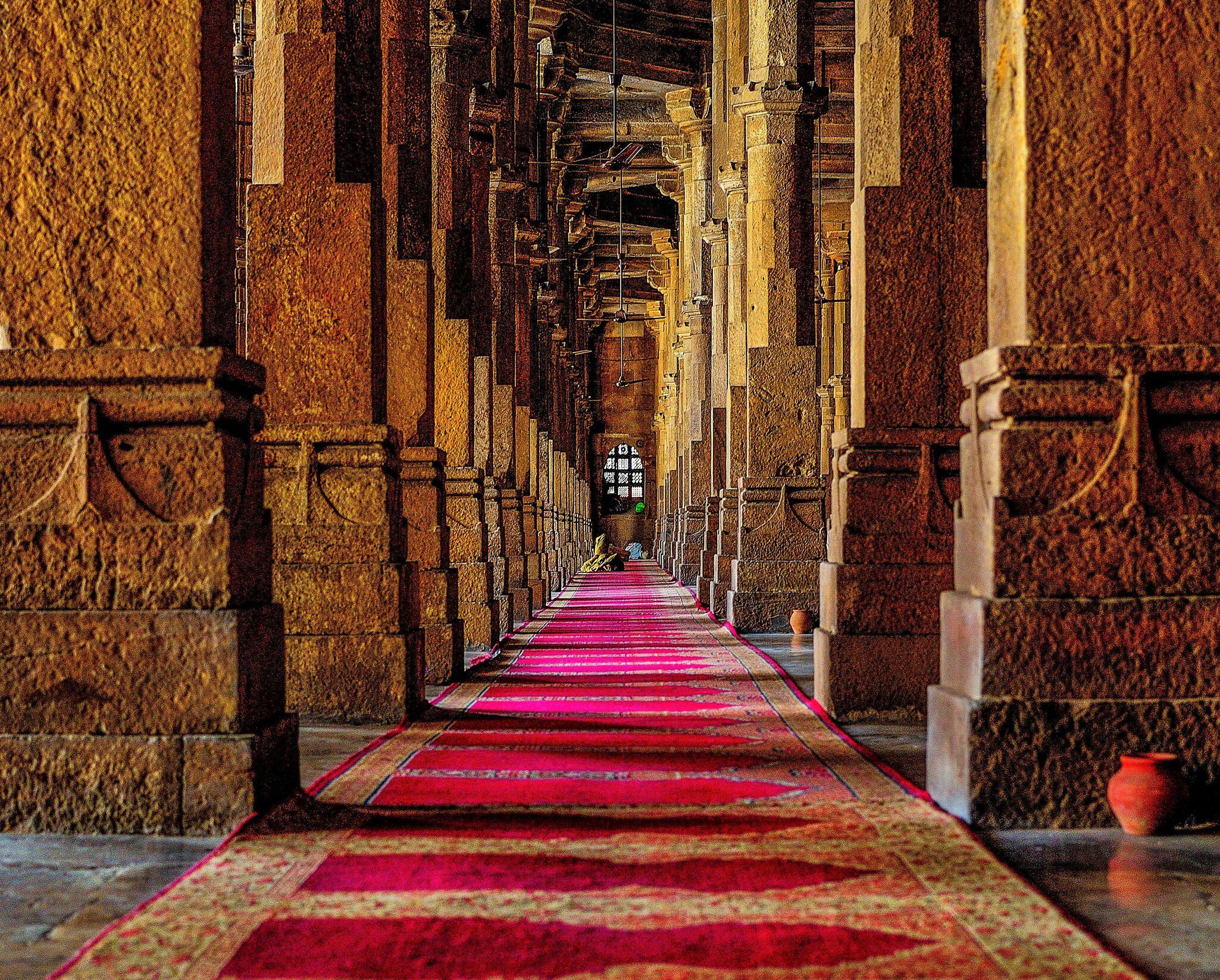 A long red carpet between pillars inside the Jama Masjid at Ahmedabad, Gujarat, India.