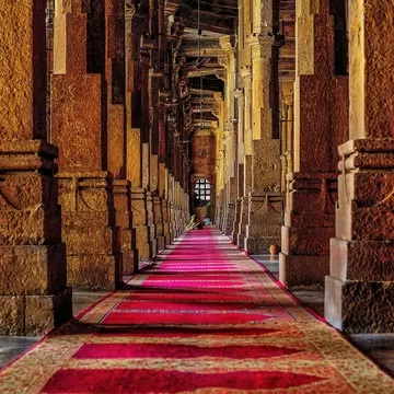 A long red carpet between pillars inside the Jama Masjid at Ahmedabad, Gujarat, India.