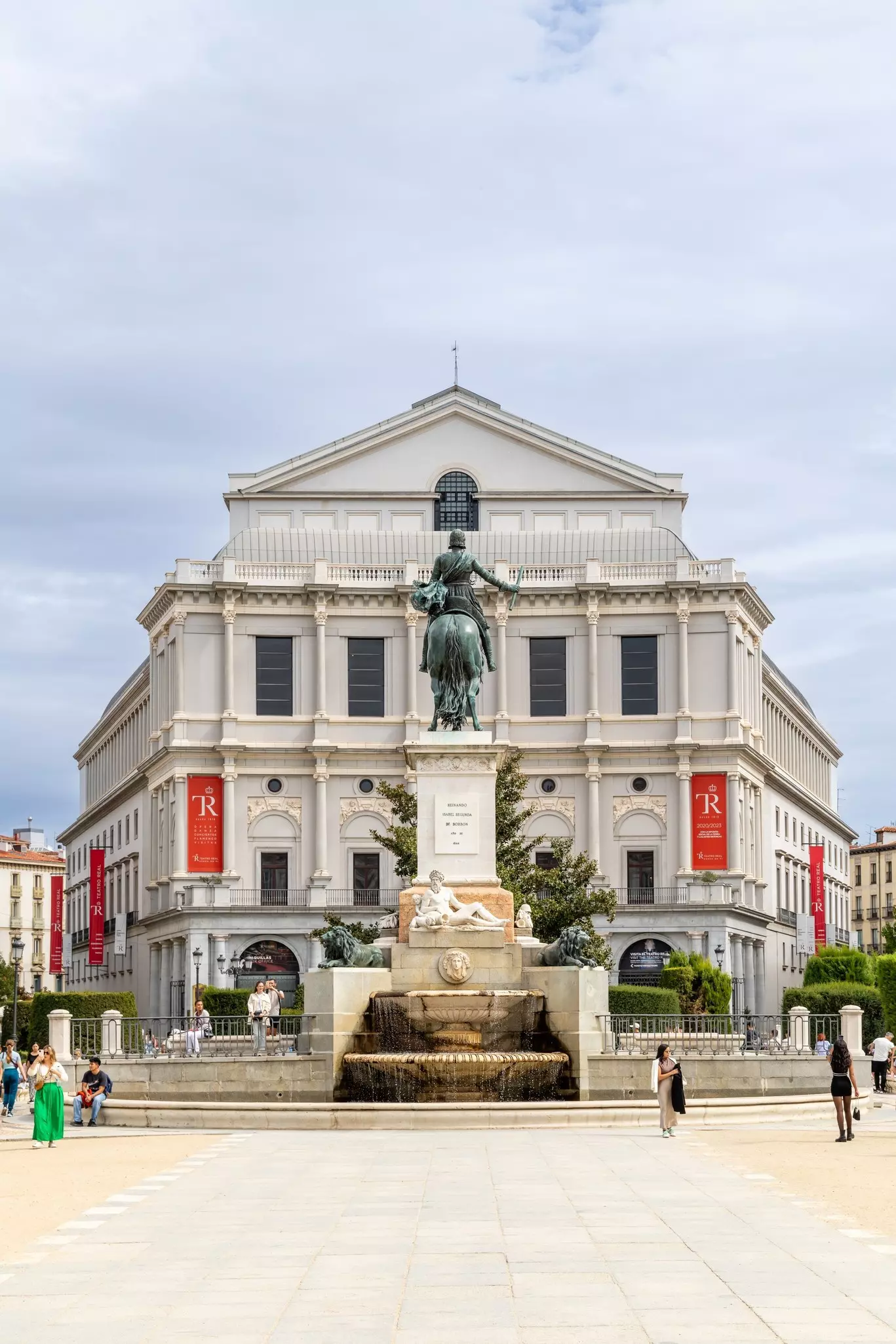 Facade of the Real Theater of Madrid with tourists walking around in Madrid, Spain.