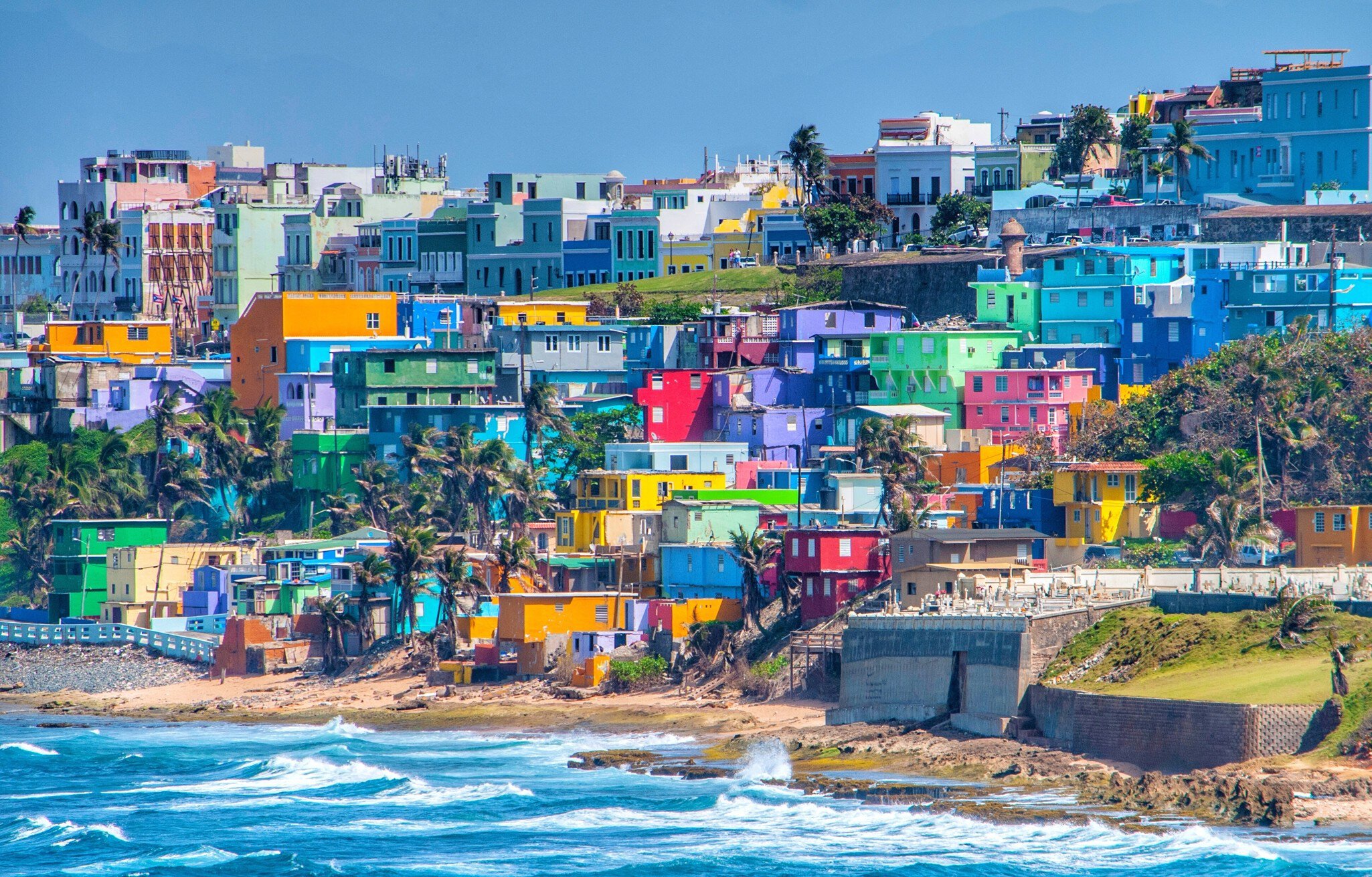 Colourful buildings on a hillside by the sea.