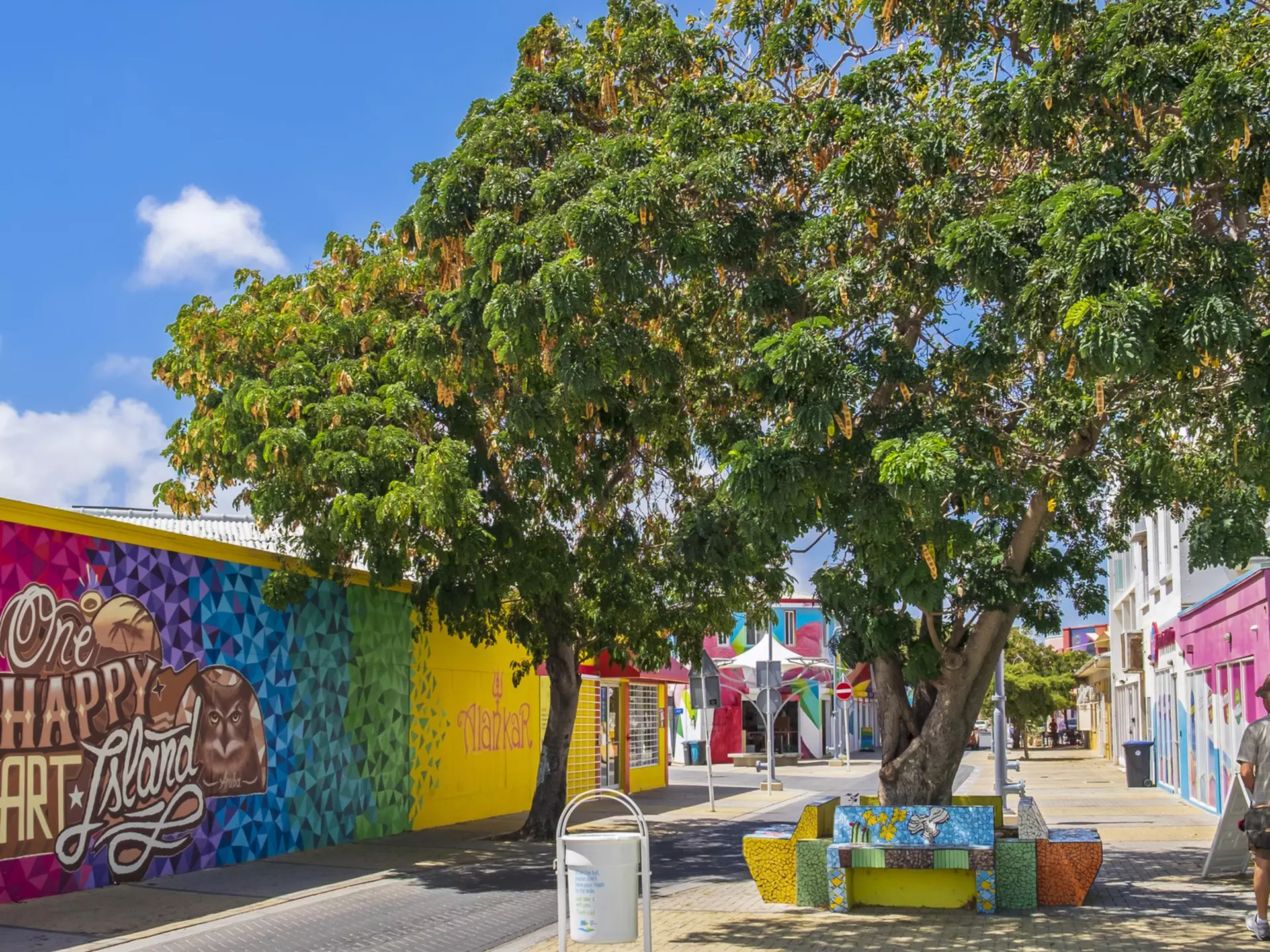 A small street lined with brightly colored wall paintings.
