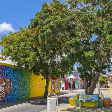 A small street lined with brightly colored wall paintings.