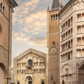 Crowds of tourists outside the Parma Cathedral next to the bell tower and the octagonal Baptistery.