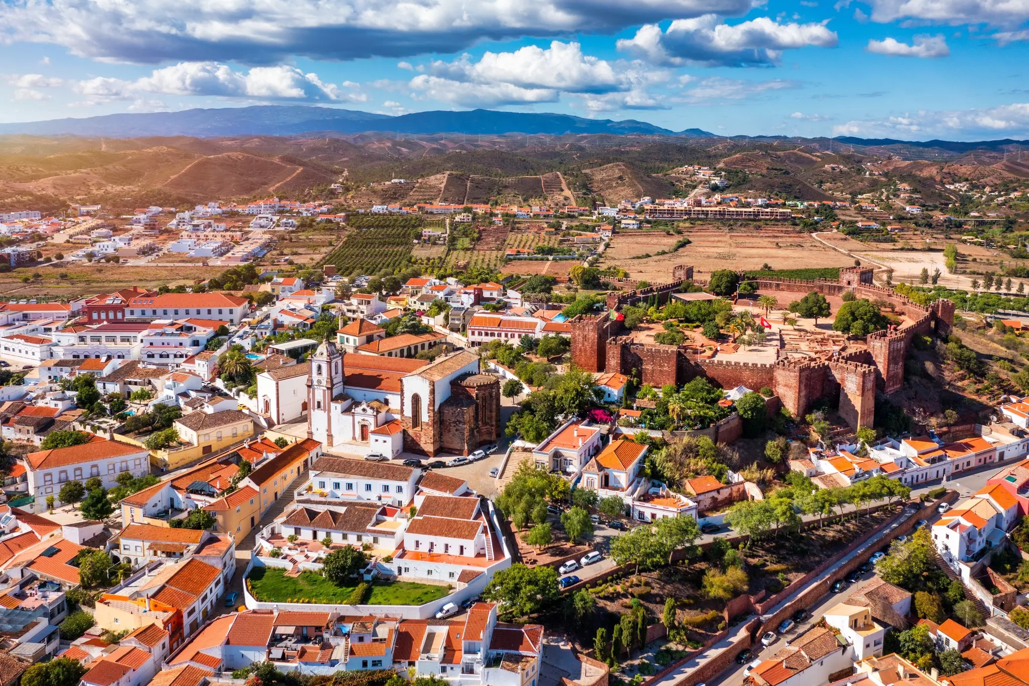 Aerial view of historic sun with red-roofed buildings on a bright day.