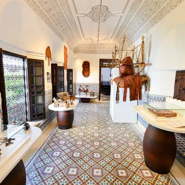 Objects displayed in cases in a room with white walls and a patterned tiled floor.