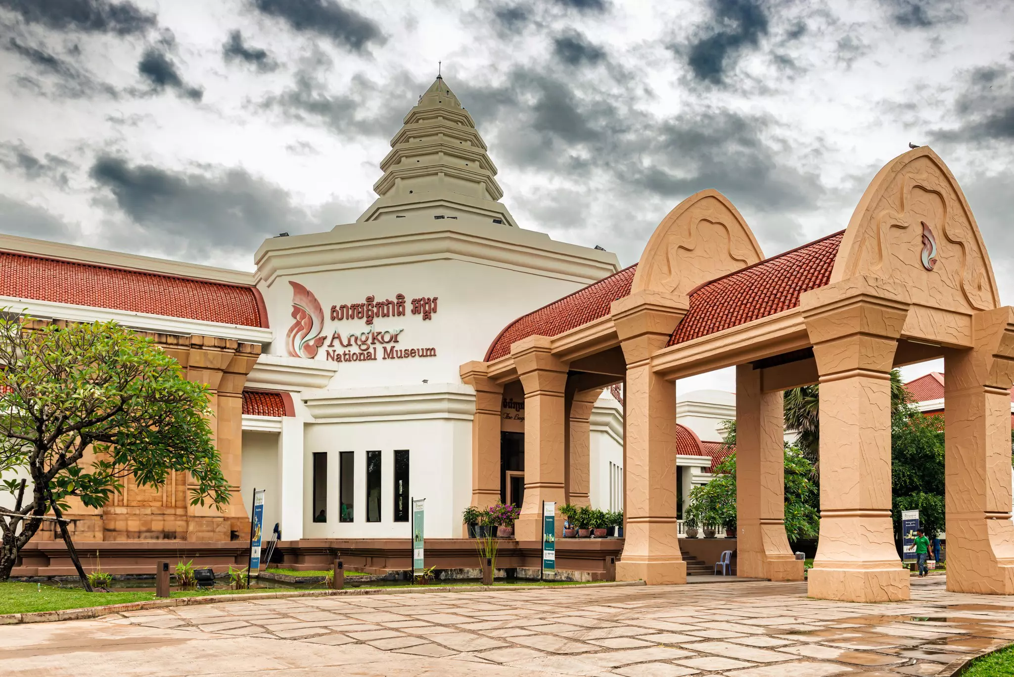 The entrance to a large museum building under gray clouds.