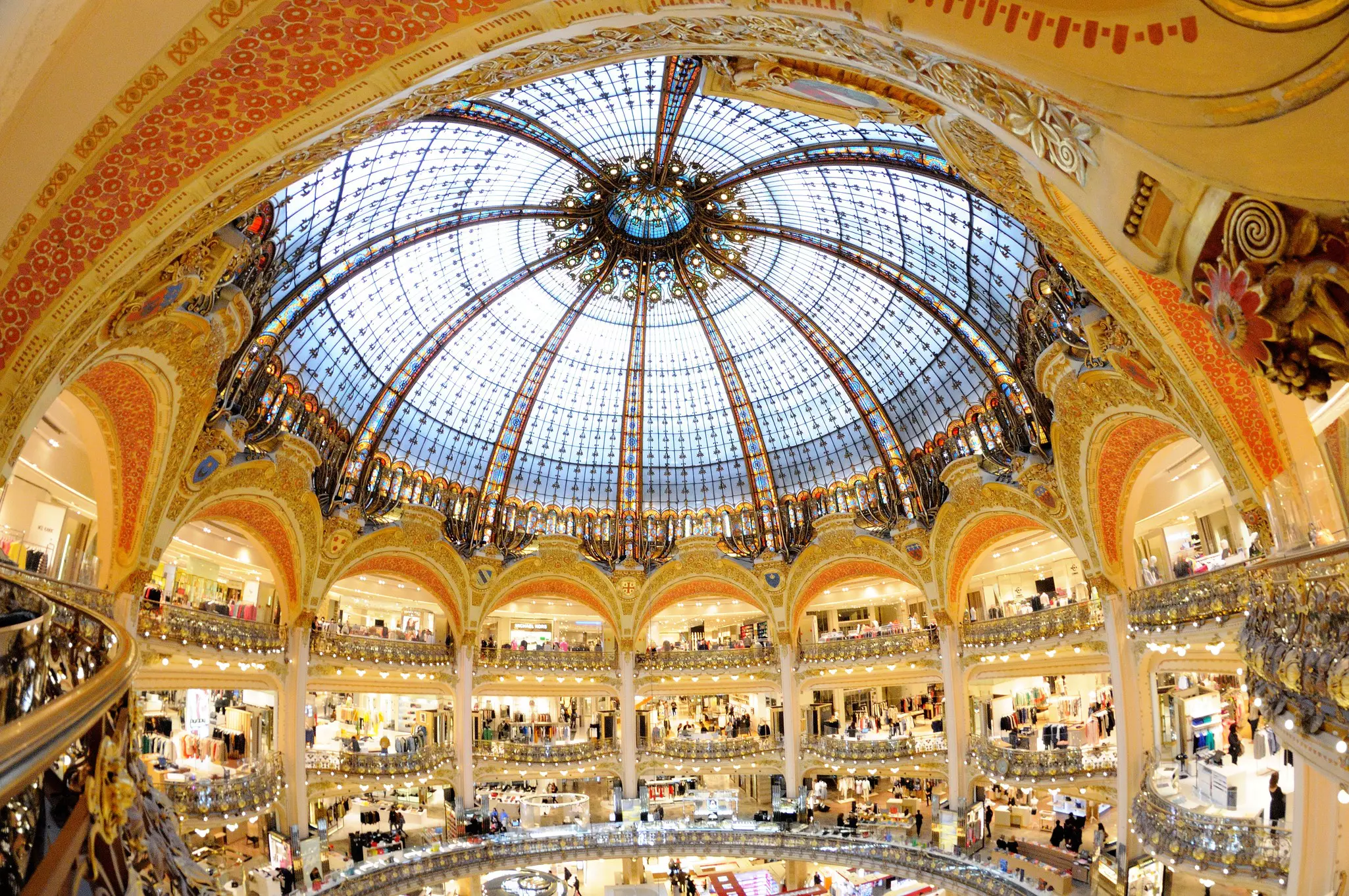 A stained glass dome above a rotunda, with archways on multiple levels.