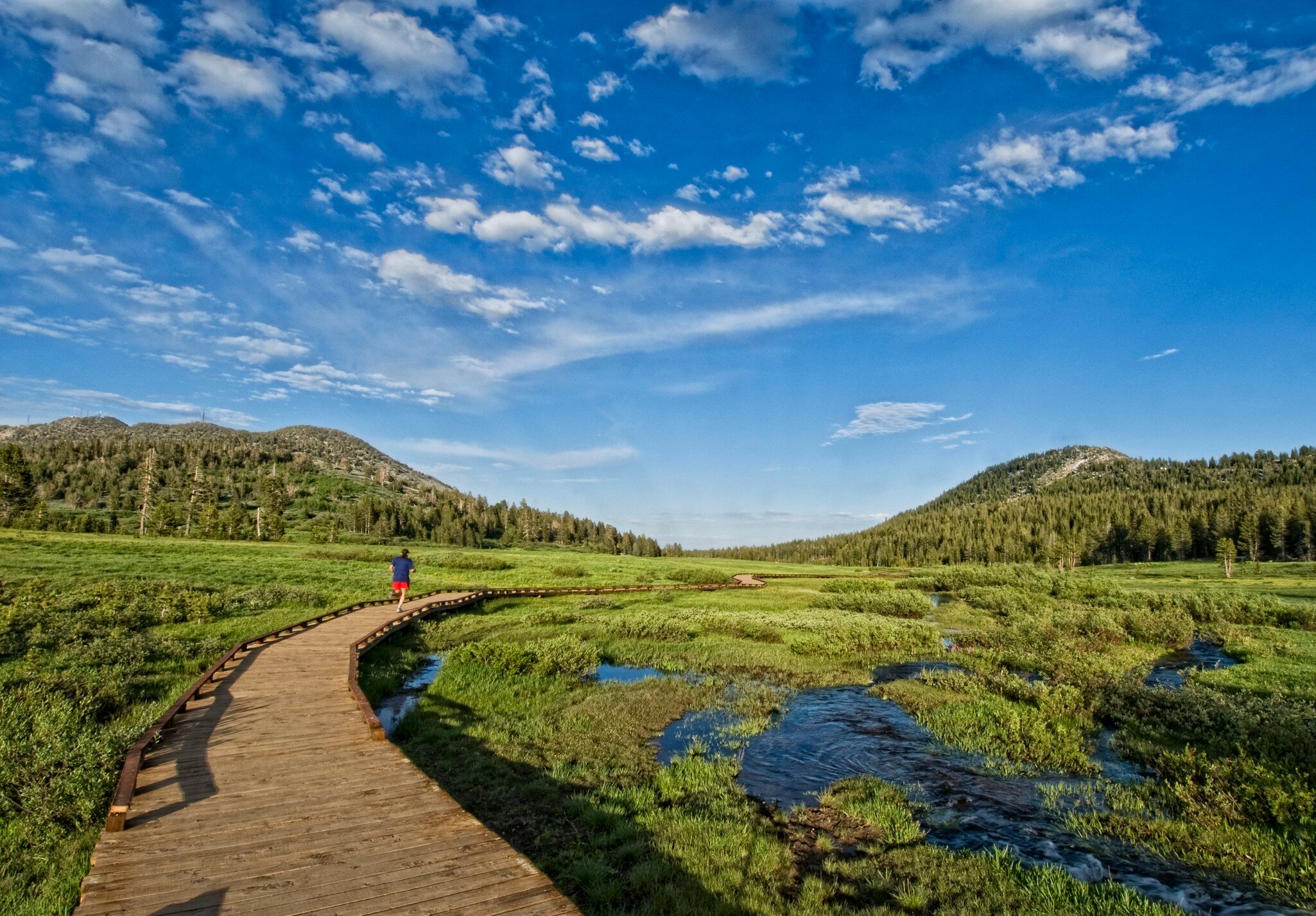 Keri Oberly follows the wooden path leading to the trail, while out for her evening exercise in Lake Tahoe, Nevada.