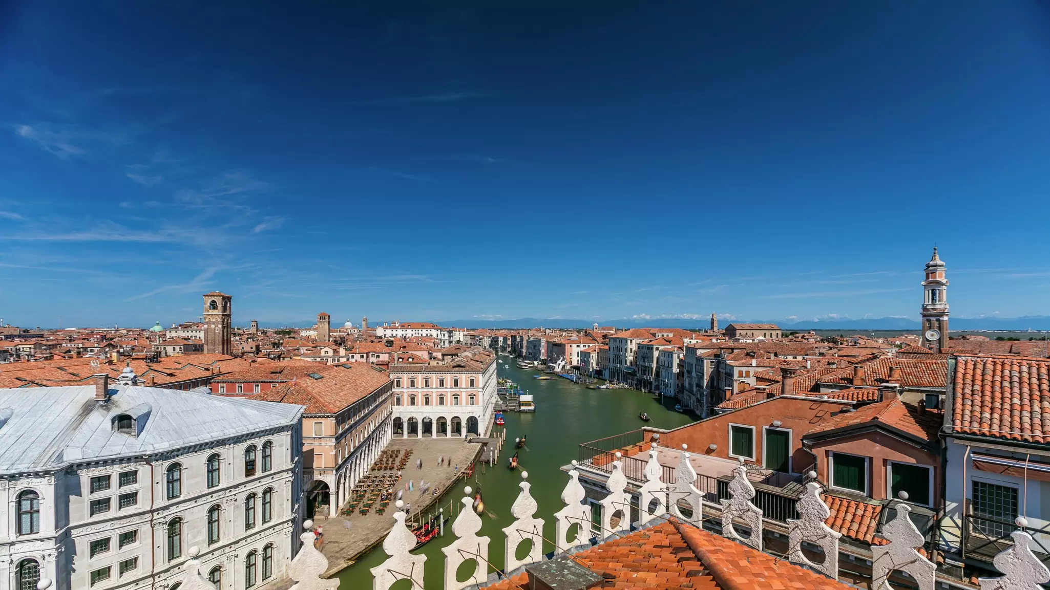 Top panoramic view on central busy canal in Venice timelapse, on both sides masterpieces of Venetian architecture, with lots of tourists sailing on gondolas and boats.