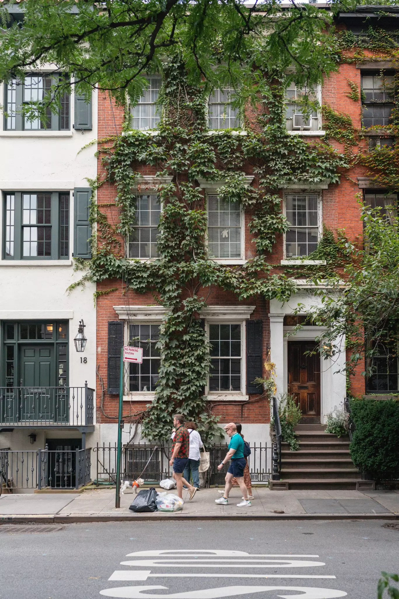 The facade of a typical New York building on Grove street. Ivy on the building