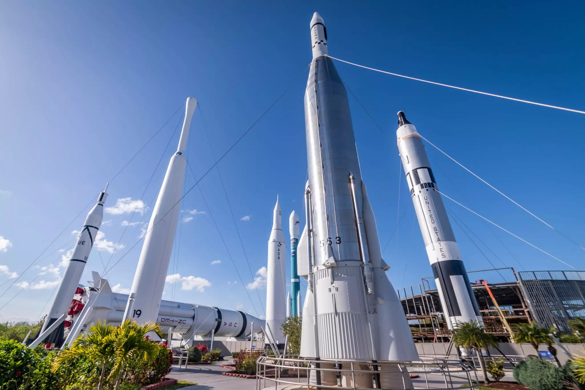 A series of space rockets standing tall in an outdoors display at a space museum.
