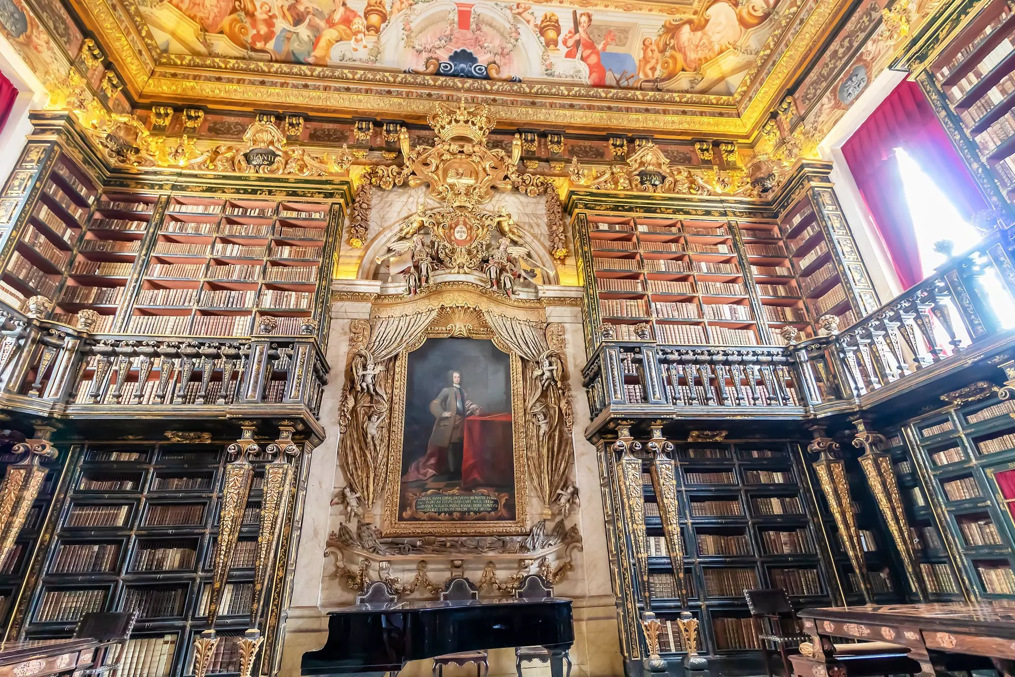 A library with ornate shelves and ceilings painted with portraiture