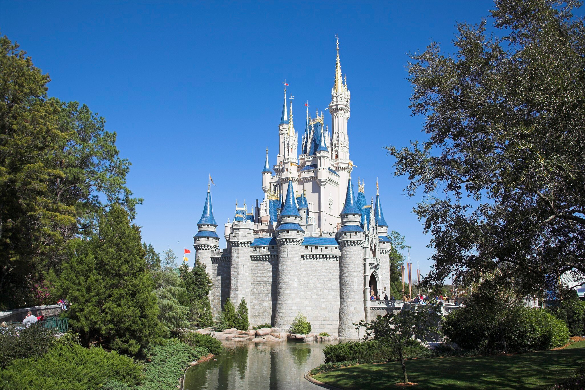 A castle with many turrets with blue accents under blue sky.