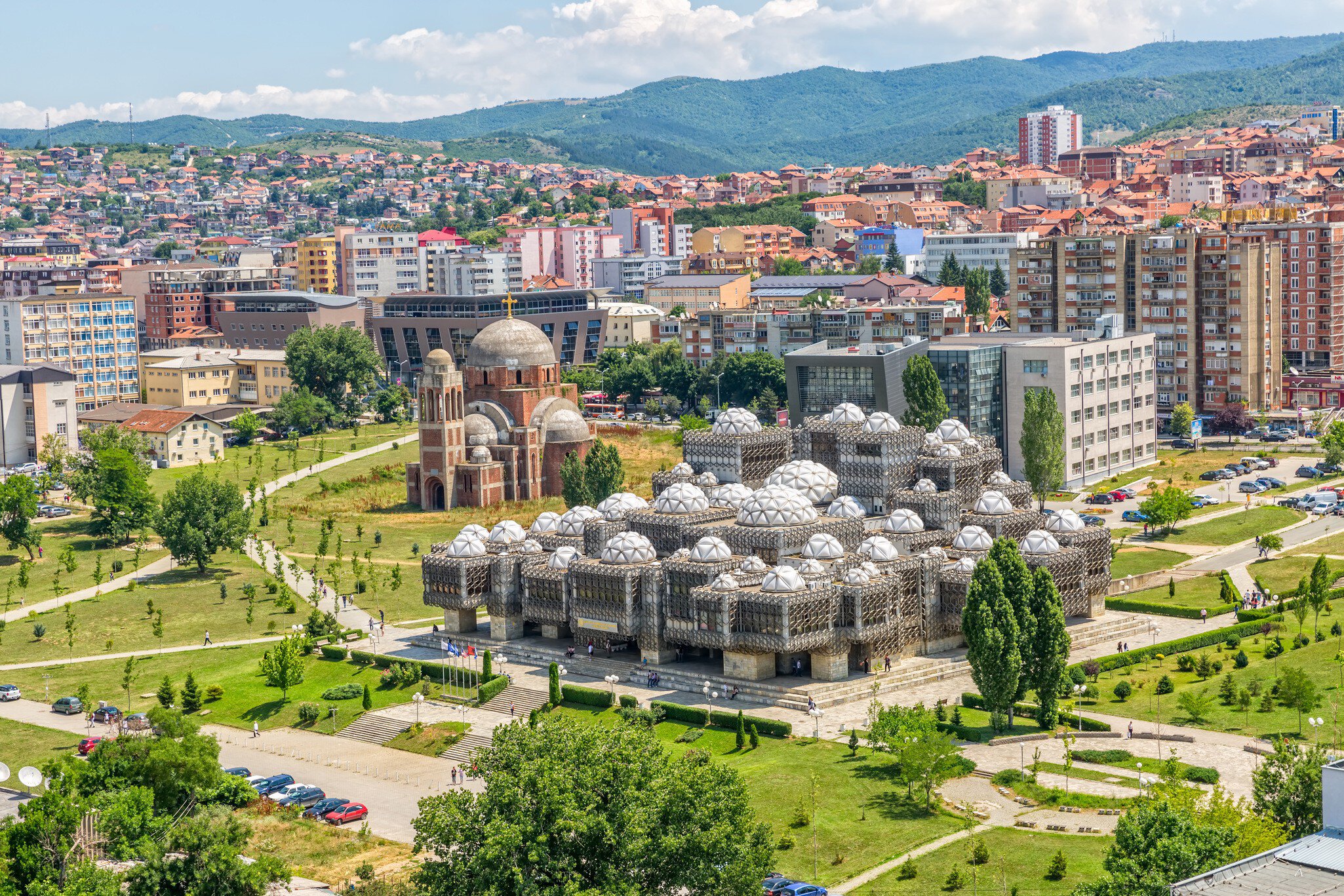 PRISTINA, KOSOVO - JULY 01, 2015: Aerial view of capital city with some old buildings like National Public Library and Christ the Saviour Cathedral.