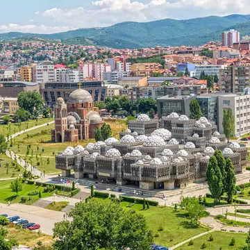 PRISTINA, KOSOVO - JULY 01, 2015: Aerial view of capital city with some old buildings like National Public Library and Christ the Saviour Cathedral.