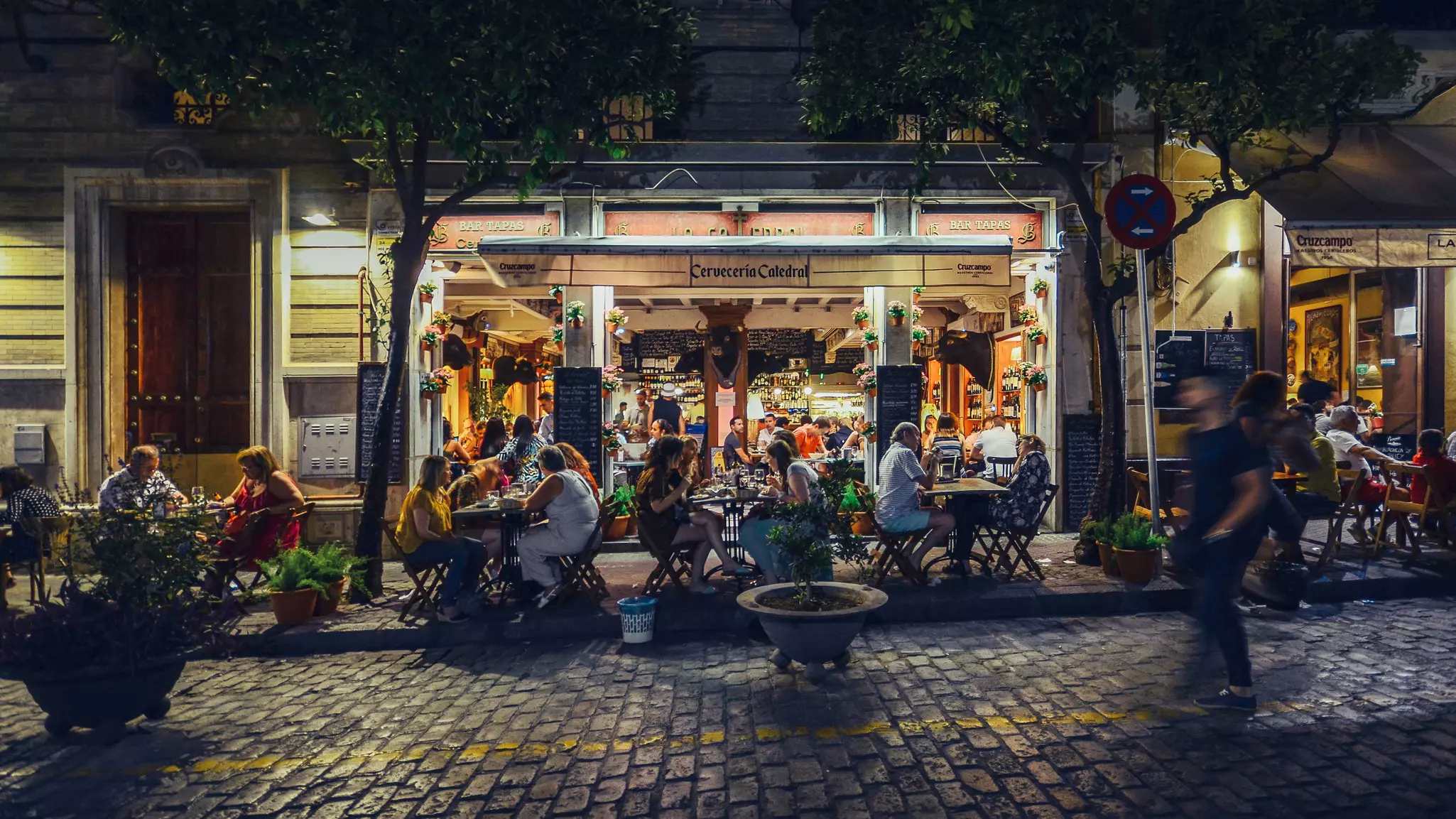 Busy bar and restaurant on Calle Mateos Gago servicing Spanish style tapas to locals and tourists well into the late hours in the historic center of Seville.