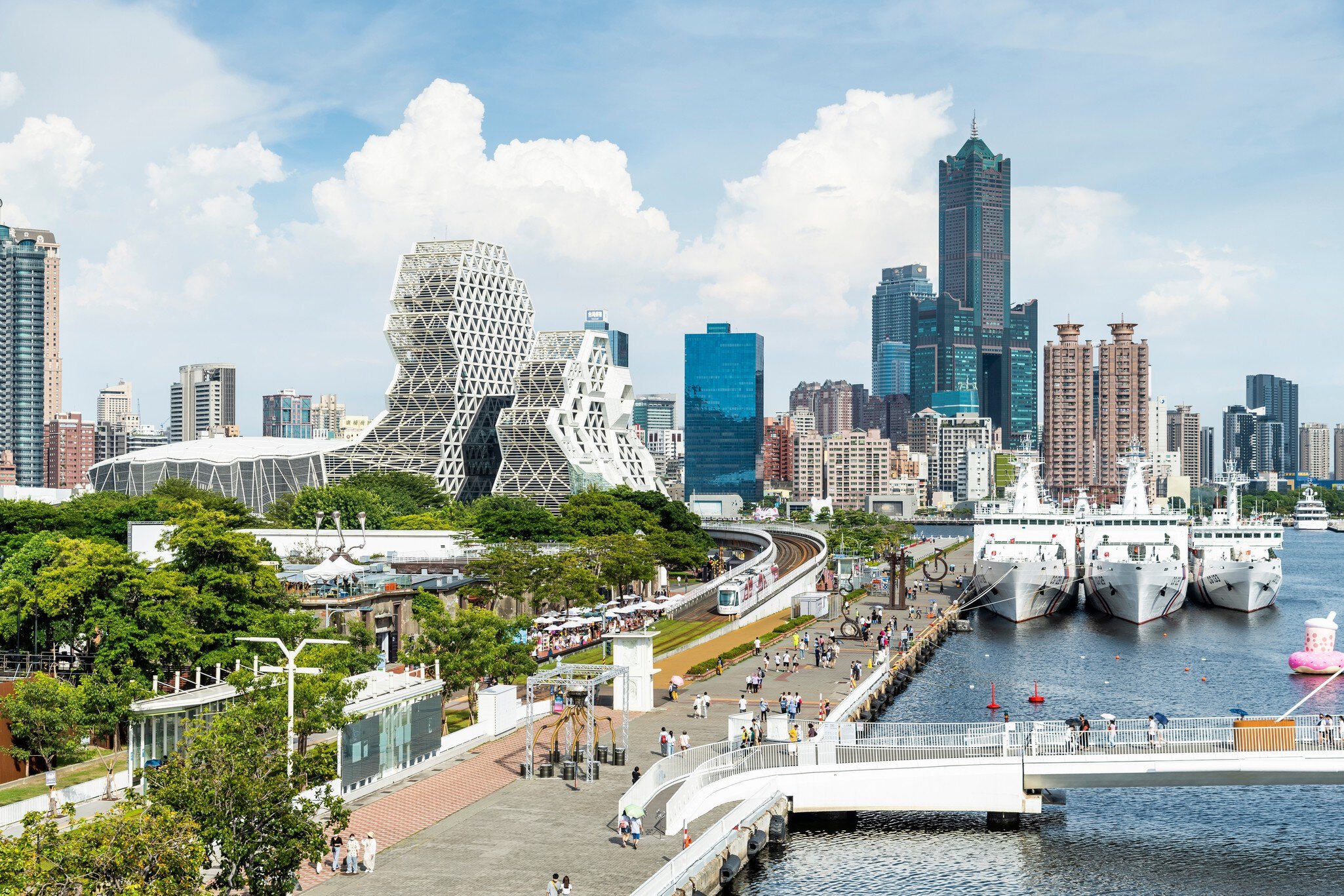 Skyline with various landmark geometrically shaped buildings and boats in the harbor at Kaohsiung, Taiwan.