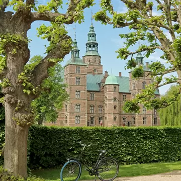 View of the Rosenborg Palace in Copenhagen, Denmark. Summer. Bicycle parked at city park in center.