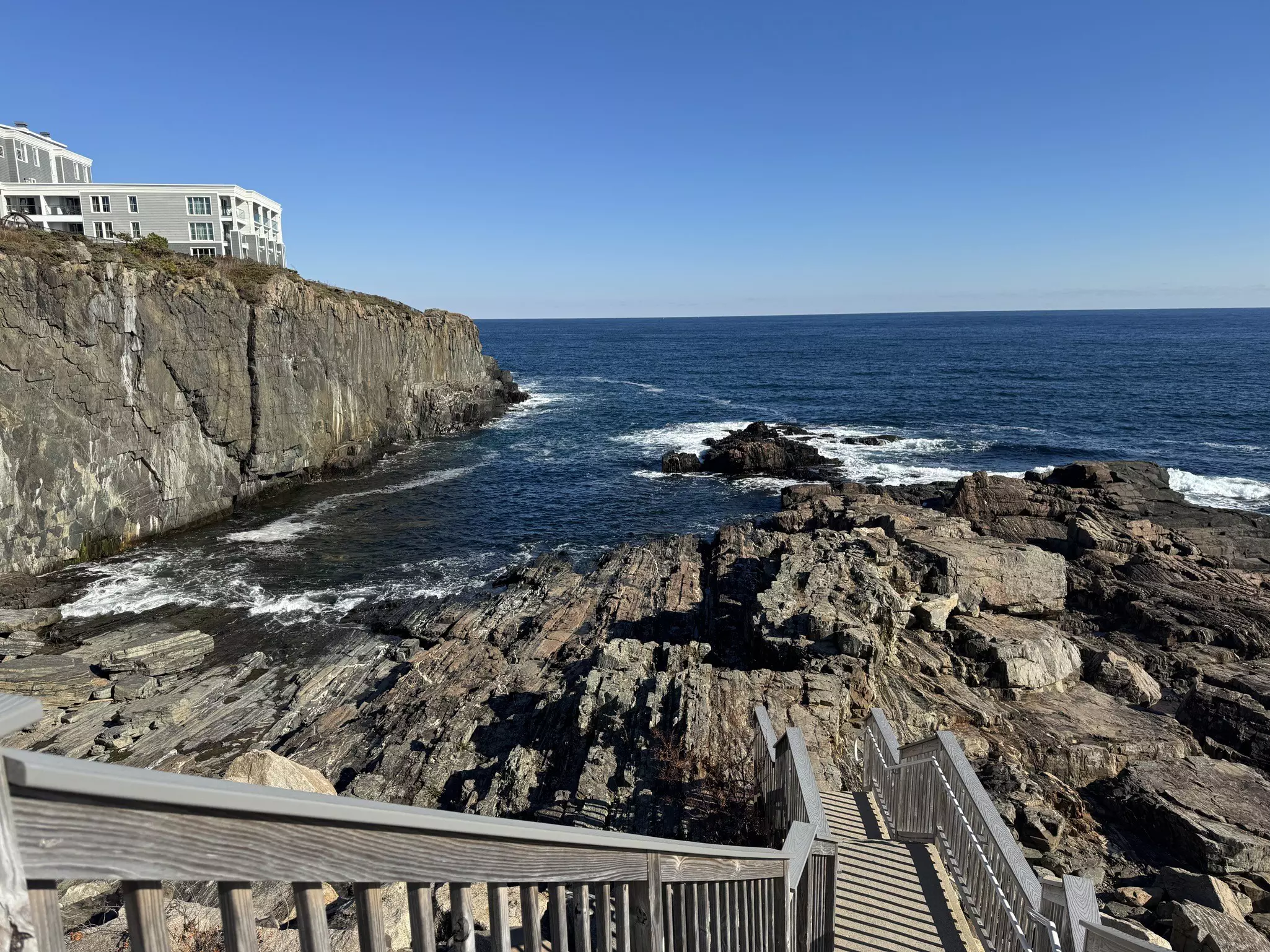 A view of a staircase, rocks and water from Cliff House in Ogunquit
