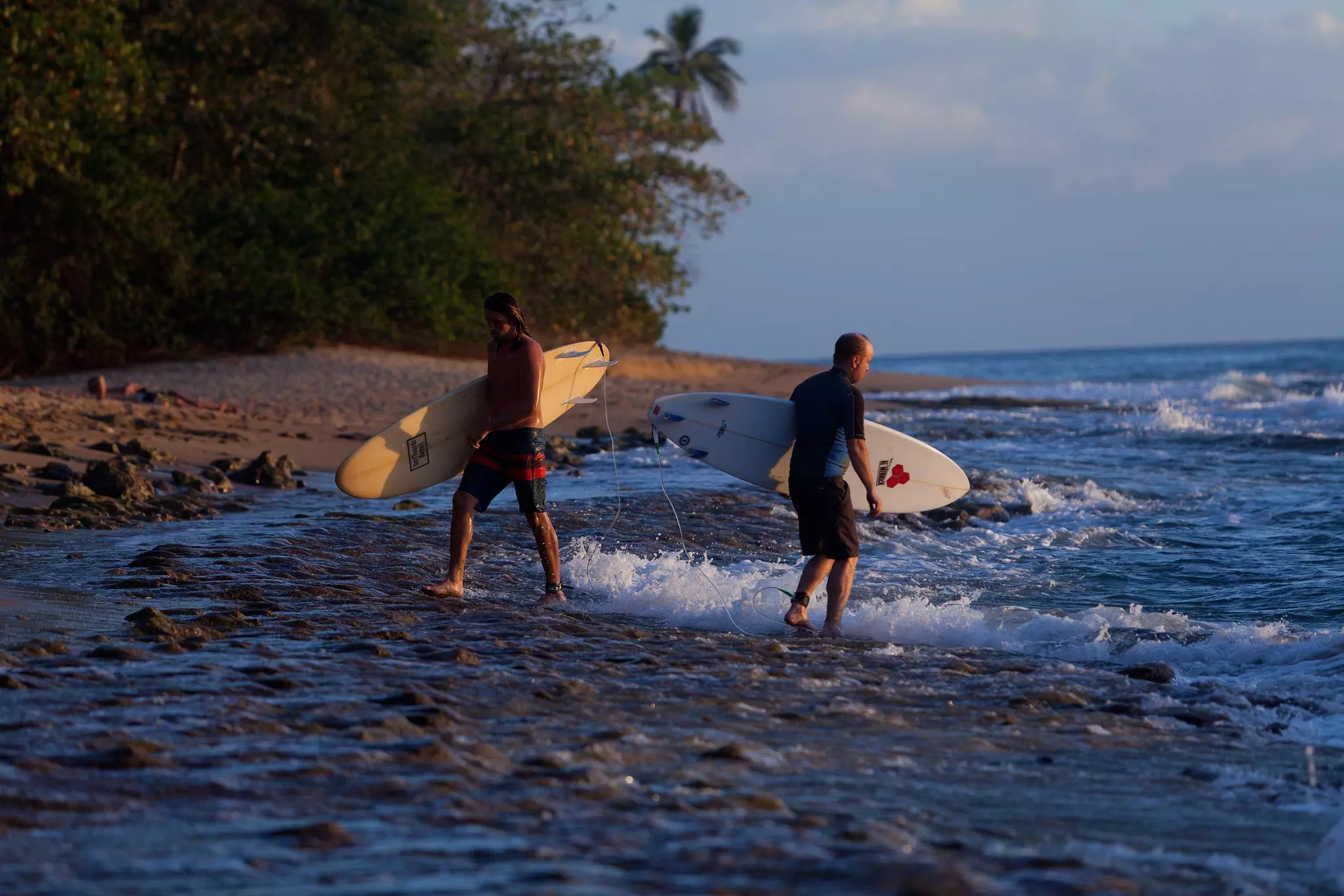 Surfers standing in the water on Domes Beach