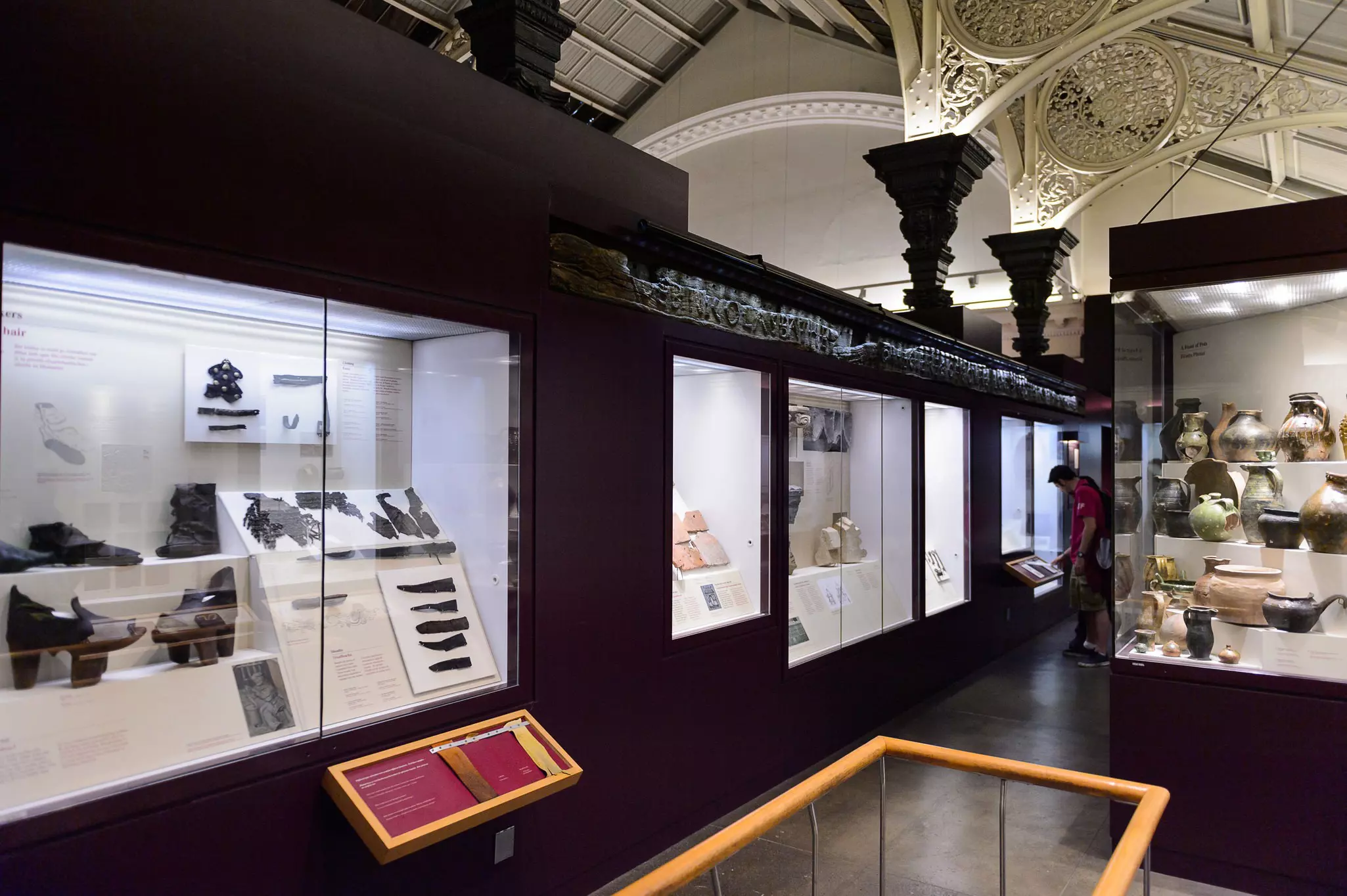 Interior image of museum showing archeological find, such as shoes, knives, and pottery.