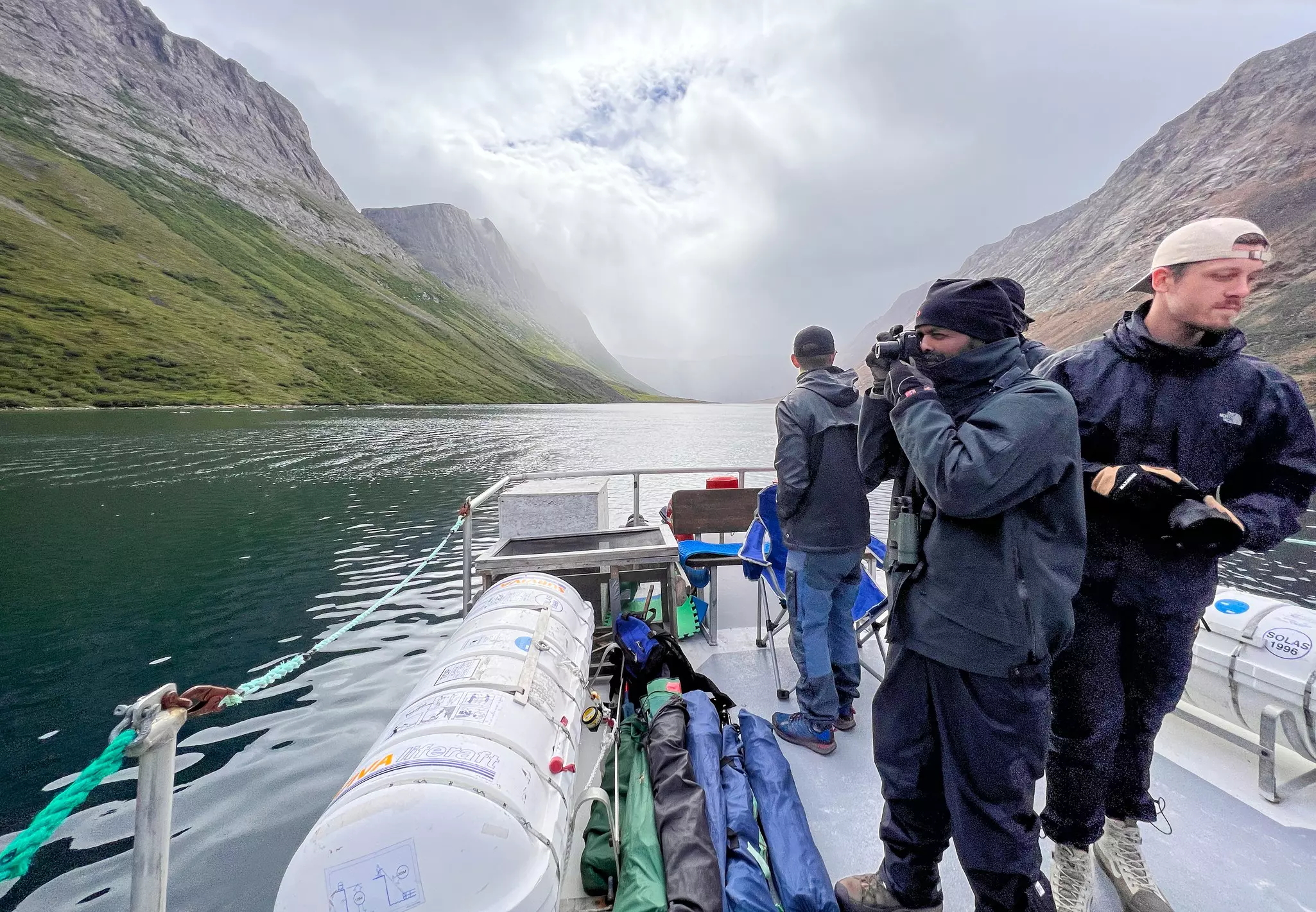 Researchers, videographers, park staff and others spy a polar bear on shore in the park © Liz Beatty