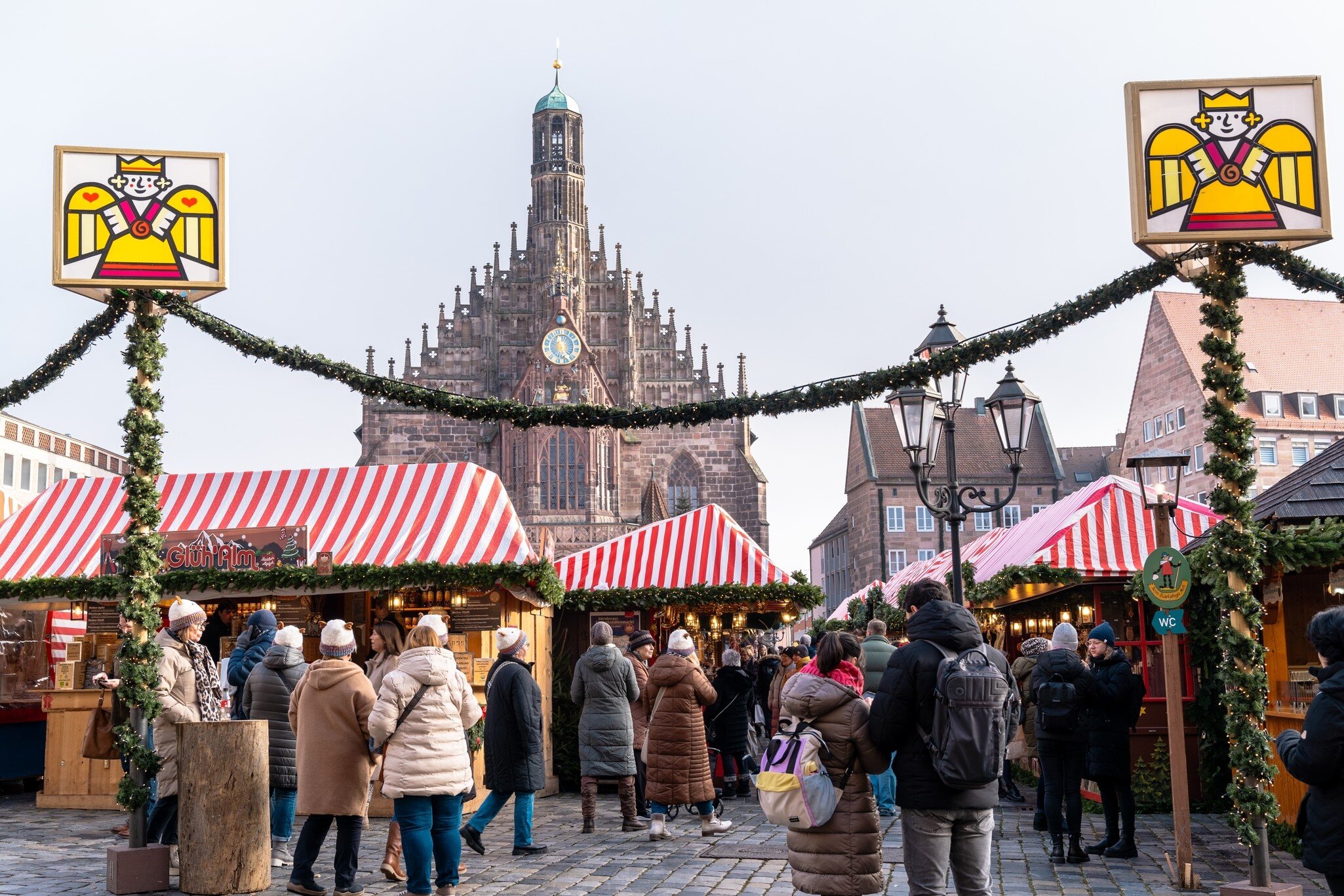 A crowd of people at the Christmas Market at the famous Nurnberg or Nuremberg, Germany. View of Hauptmarkt square and Church of Our Lady (Frauenkirche). 